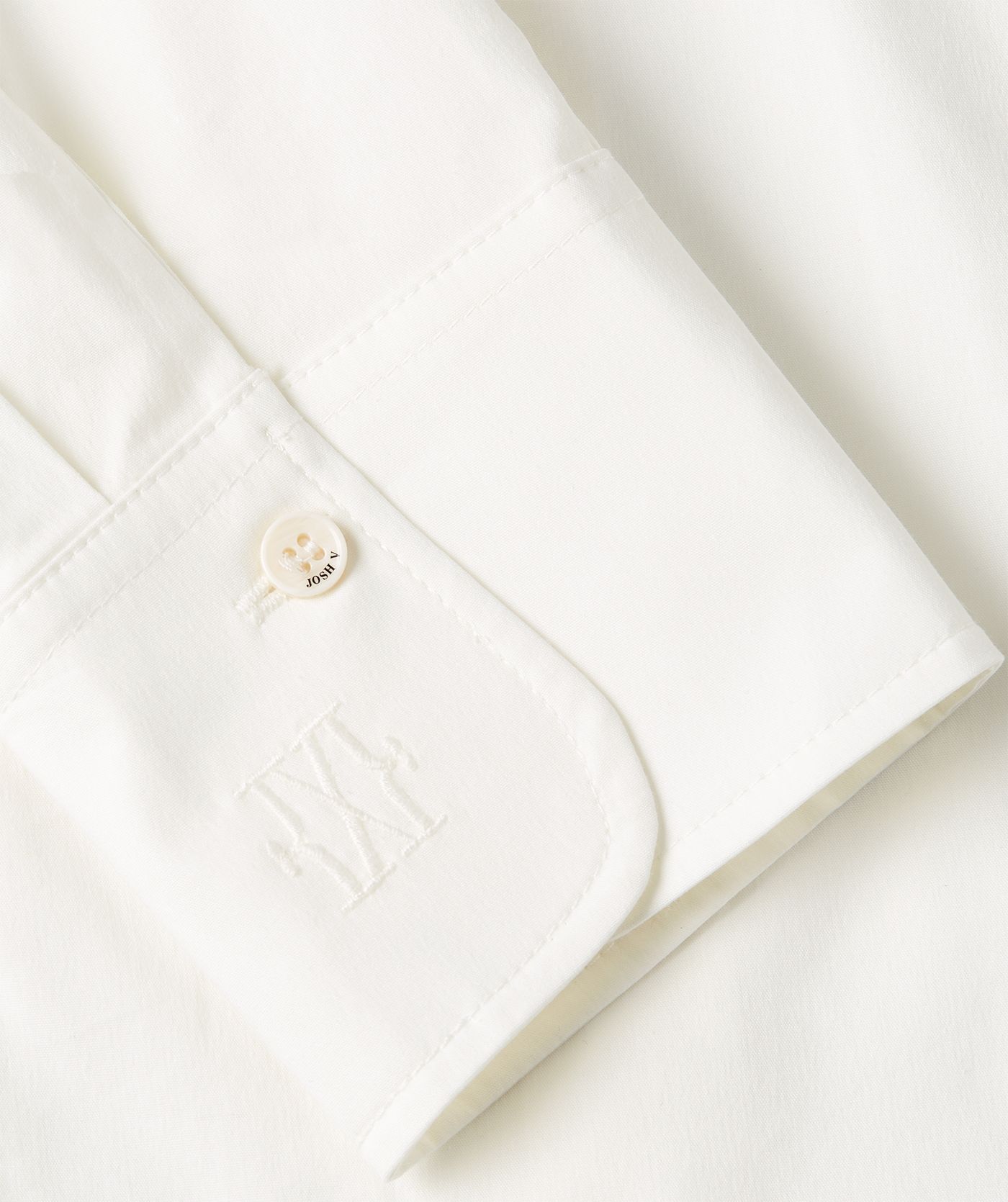 Close-up JOSH V branded knopen mouw