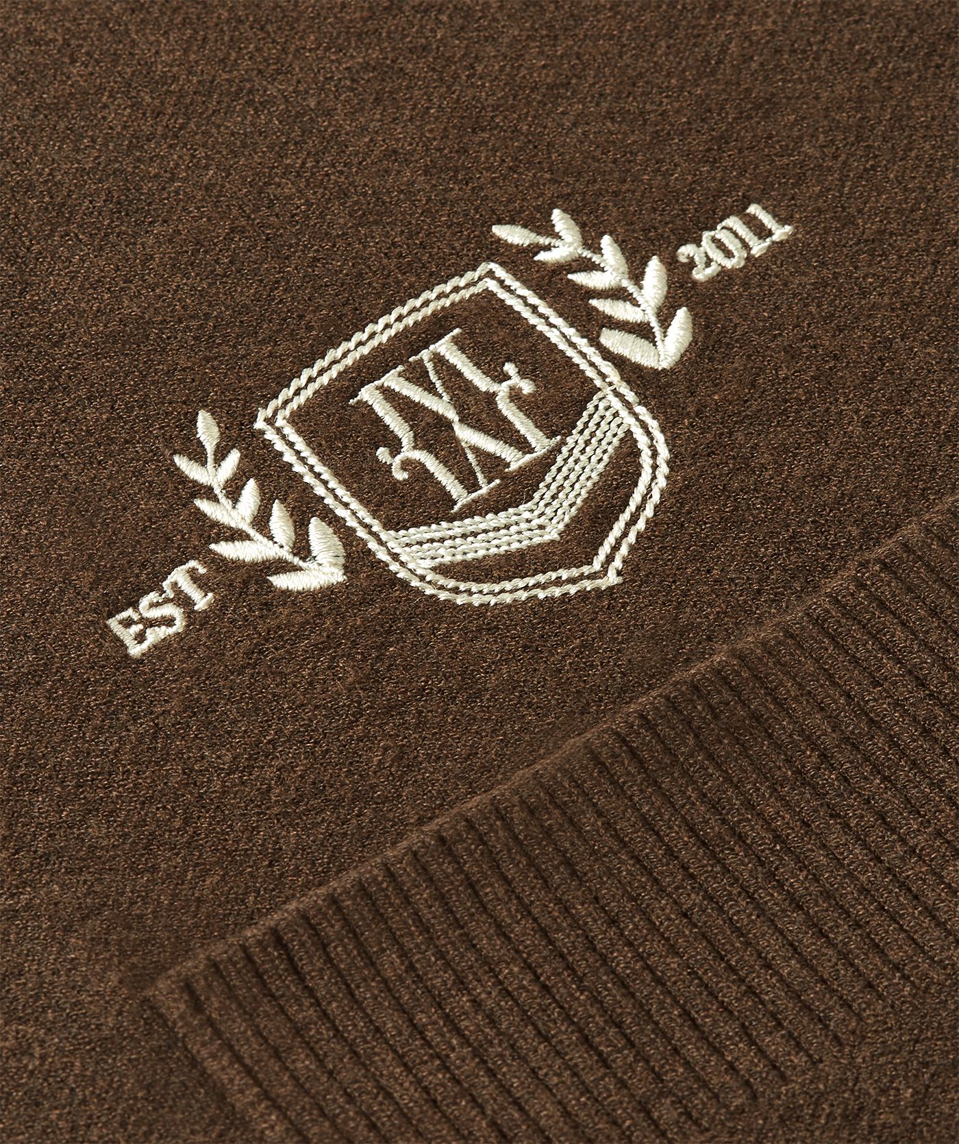 Close-up beige JOSH V detail op een donkerbruin vest.