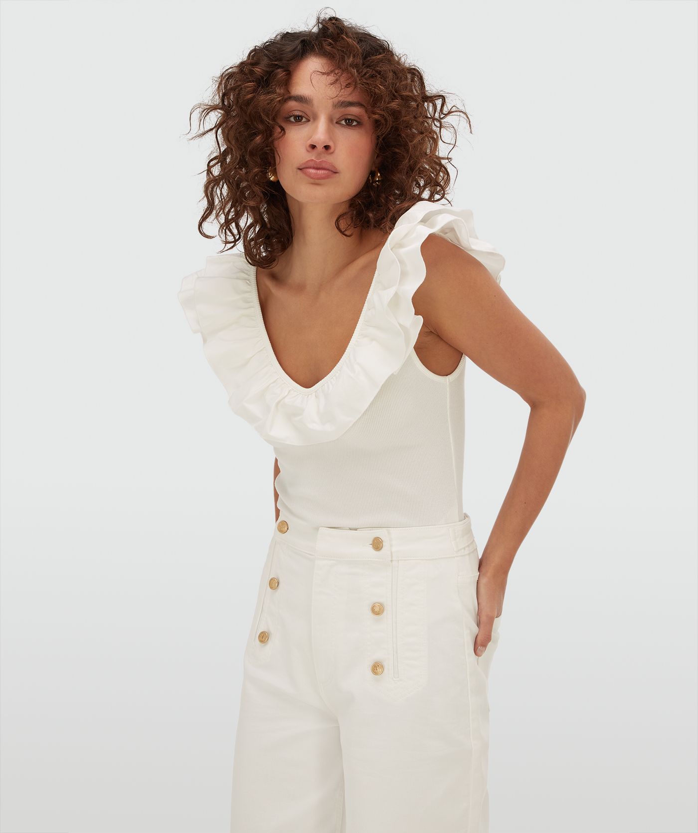 Model draagt een slim fit body met ruffle detail in de kleur Off White
