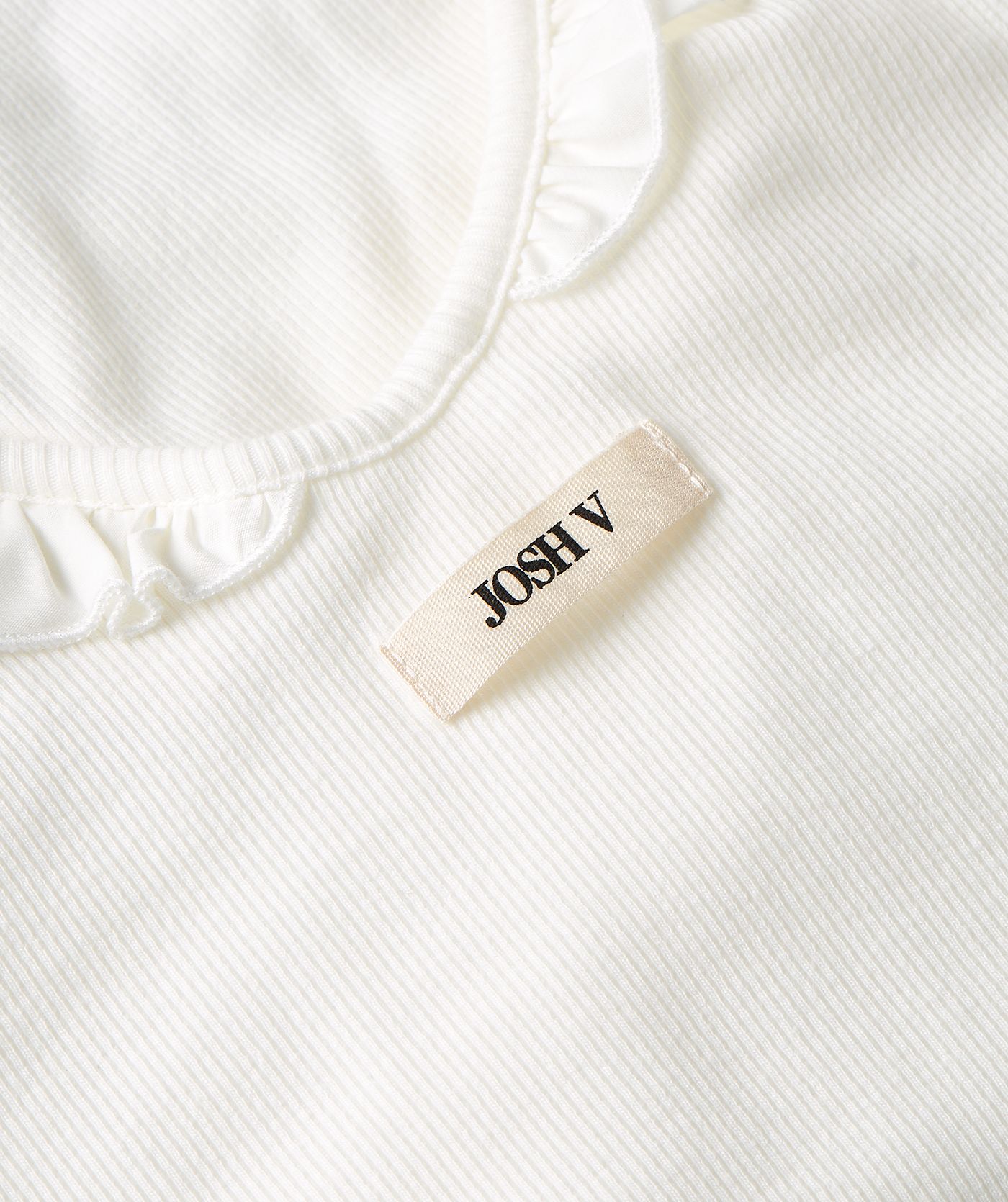 Close-up van een slim fit body met ruffle detail in de kleur Off White