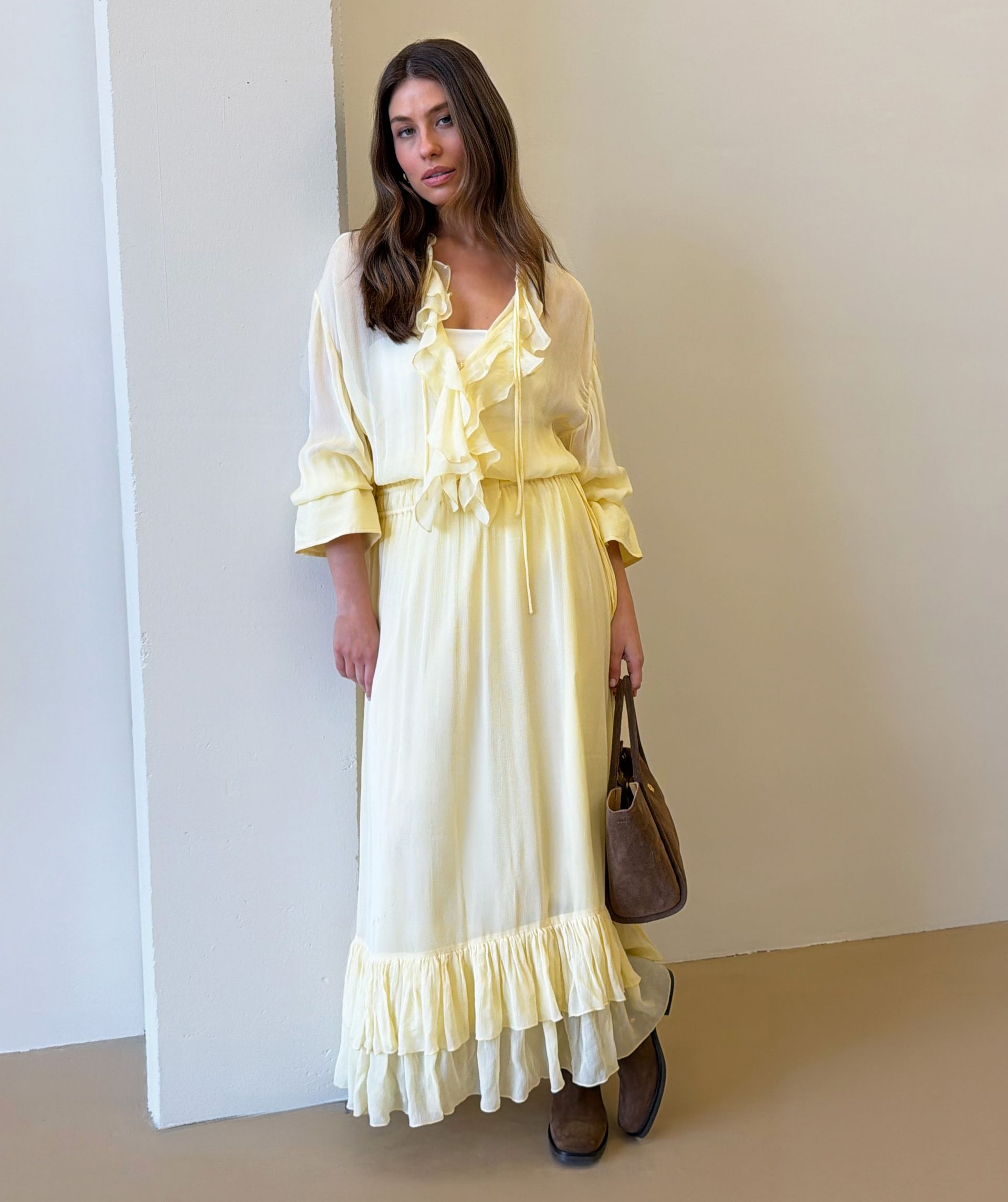 Model draagt een oversized maxi jurk in de kleur Butter Yellow