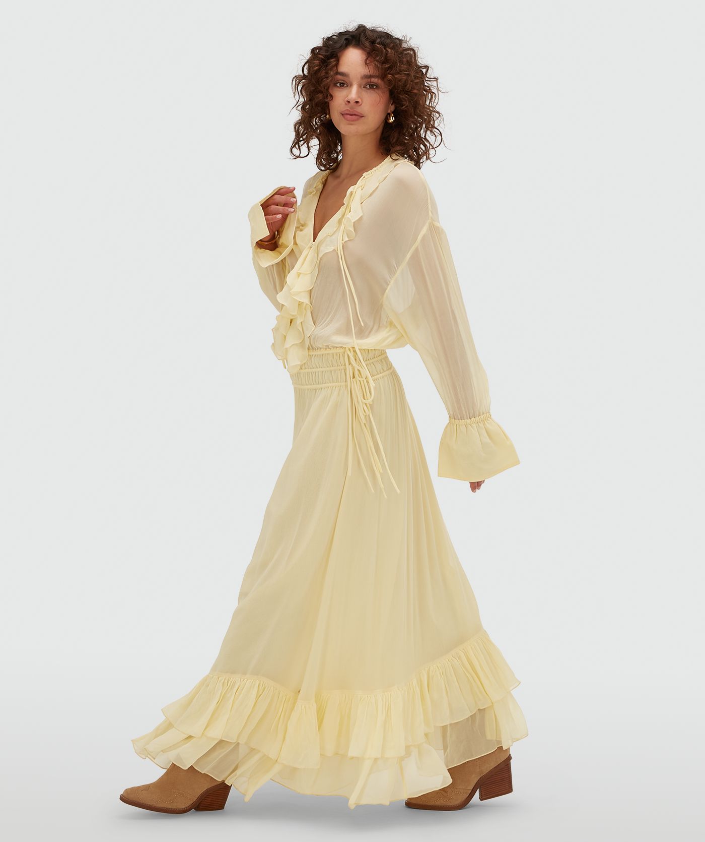 Zijaanzicht van een model in een oversized maxi jurk in de kleur Butter Yellow
