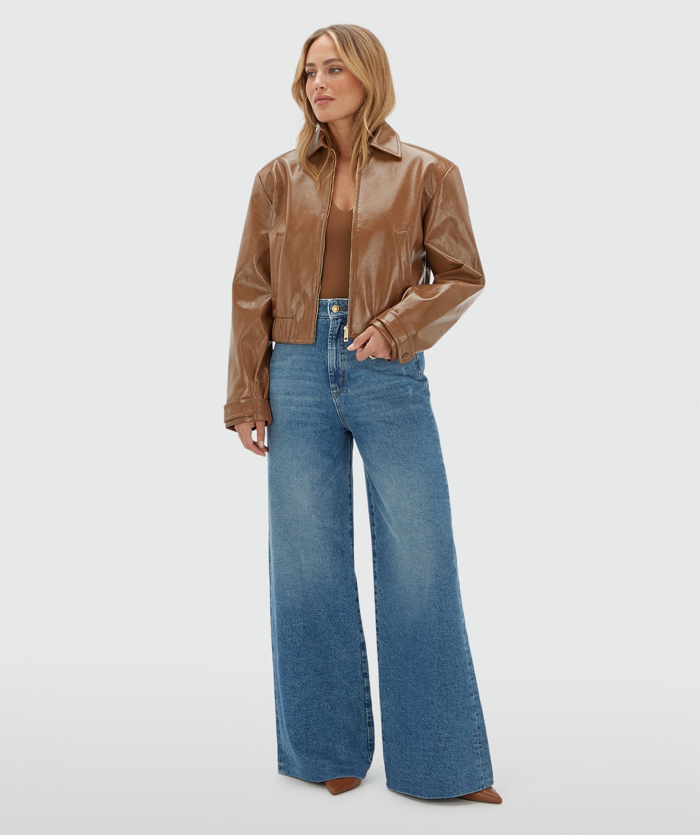 Model draagt een jeans met leren details aan de bovenkant gecombineerd met cognac top.