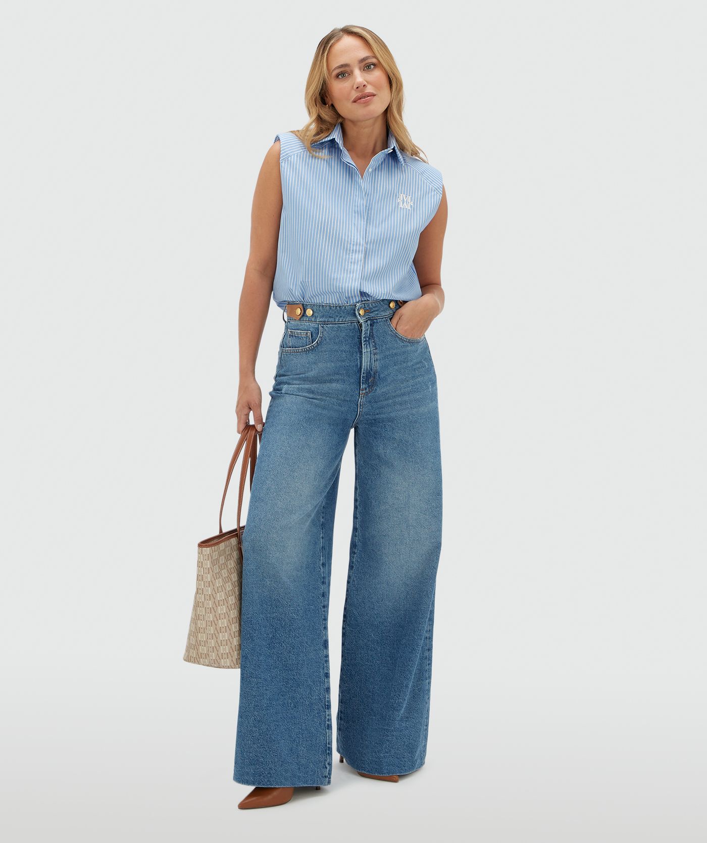 Model draagt een jeans met leren details aan de bovenkant gecombineerd met cognac top.
