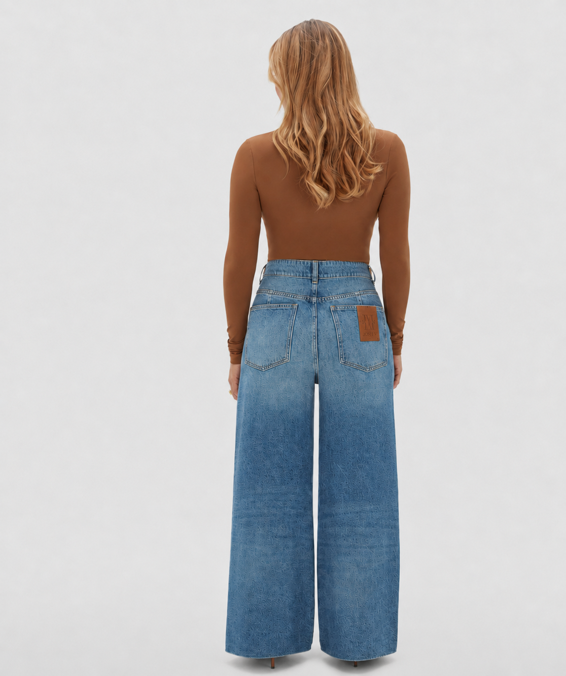 Achterkant van het leren detail op de jeans waarmee je hem in de taille strakker kan maken.