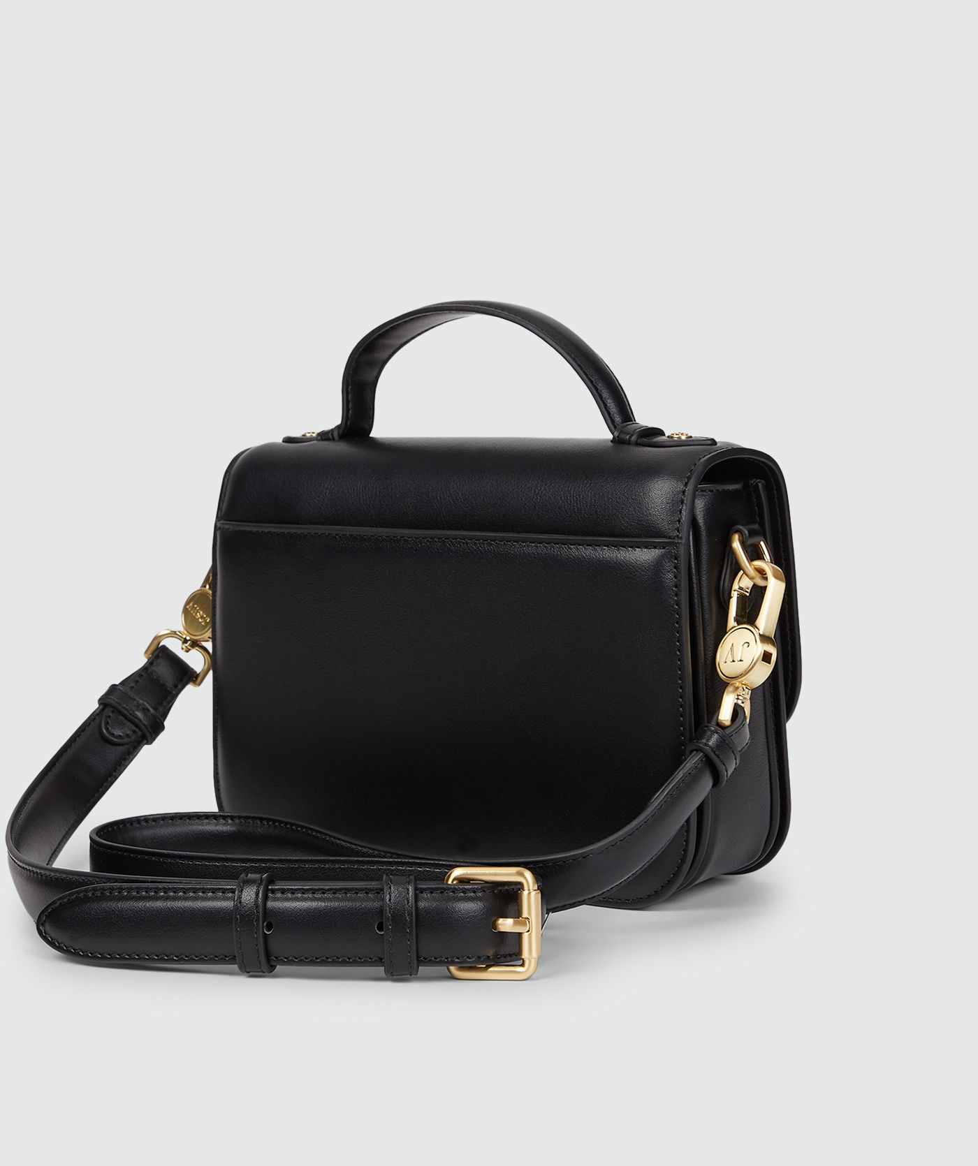 Achterzijde van een tas in het zwart met een goudkleurige bucklesluiting en een verstelbare band