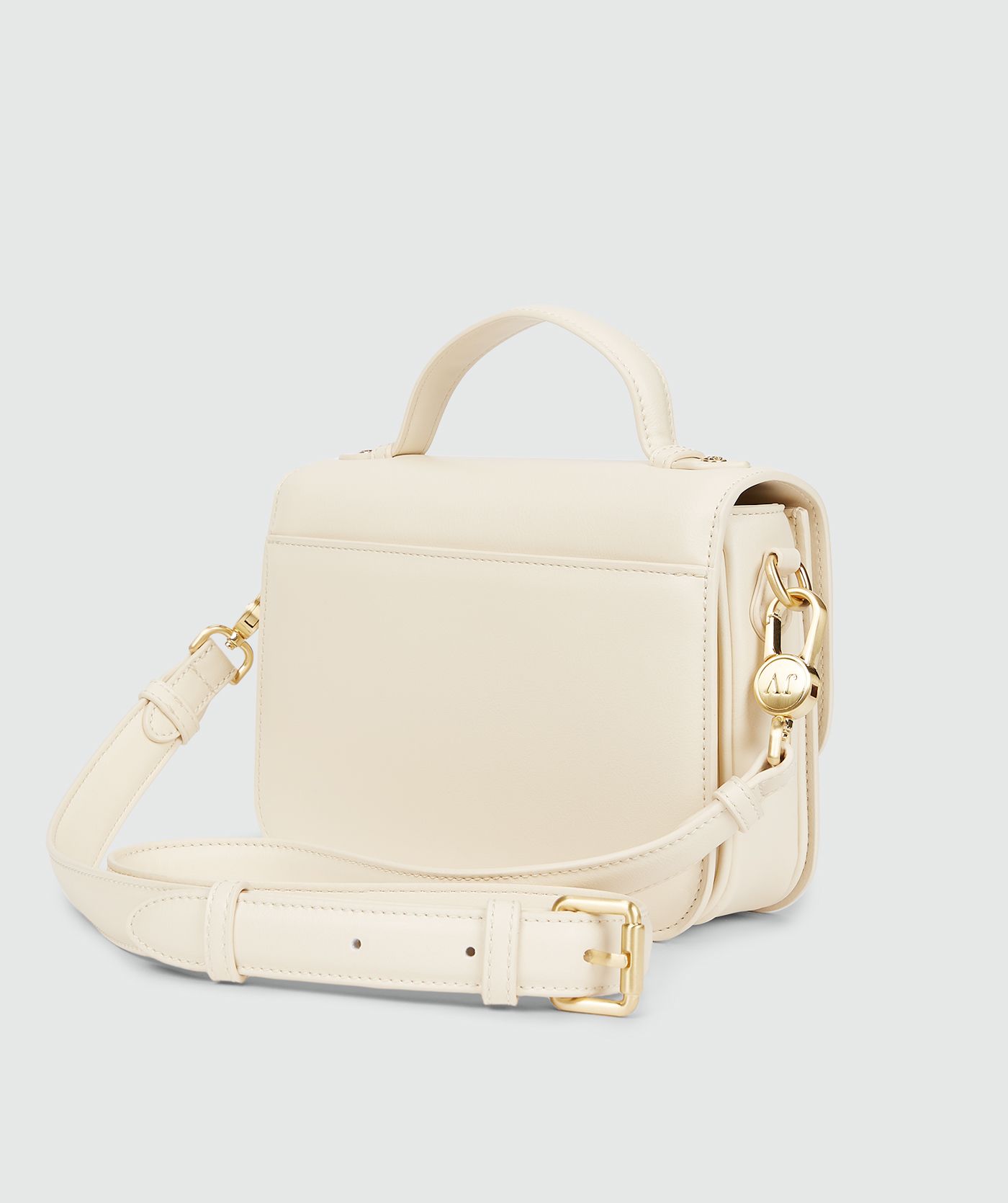 Achteraanzicht van een tas in Crème White met een goudkleurige bucklesluiting en een verstelbare band
