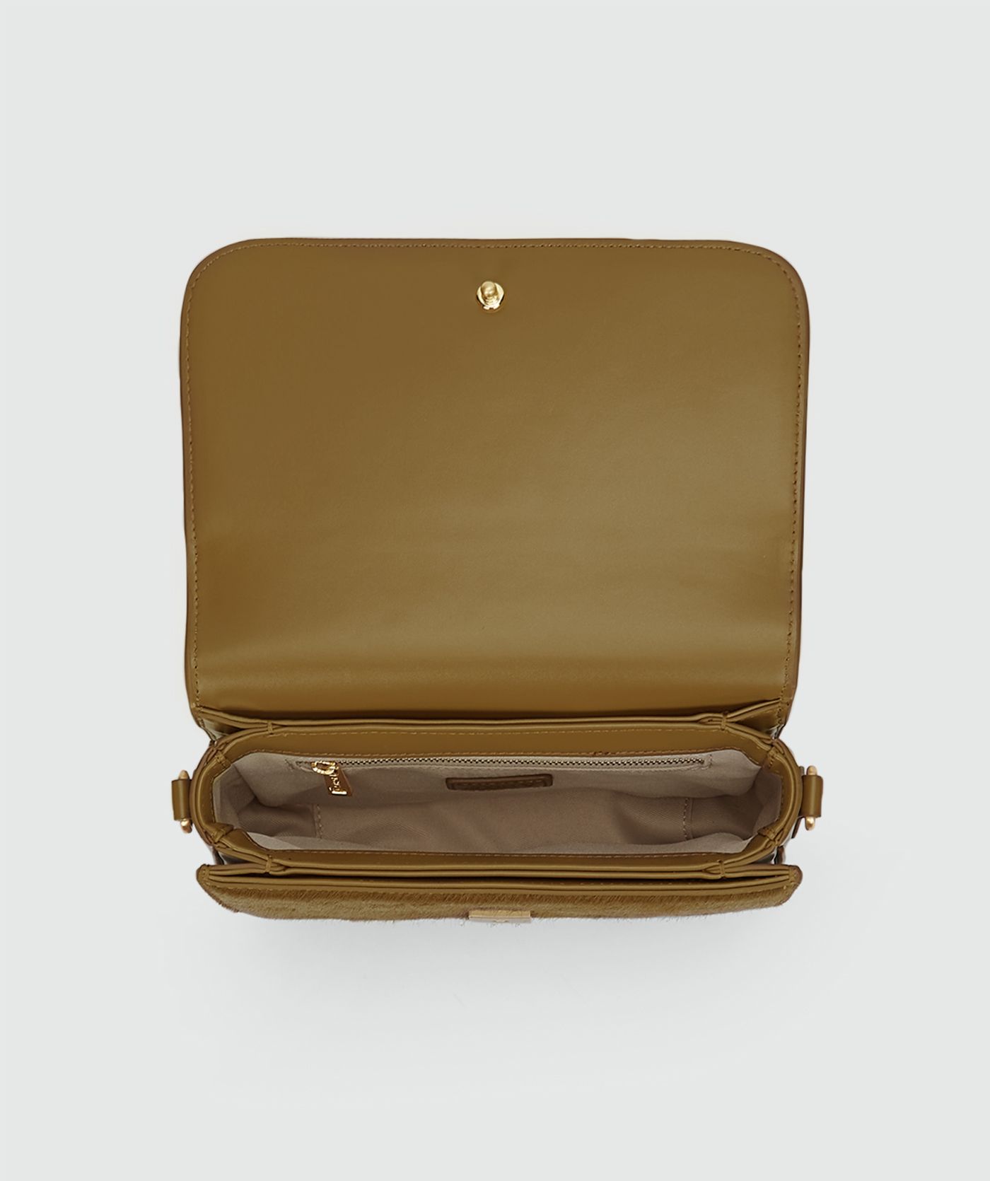Binnenkant van tas met pony haar in de kleur Khaki zonder model, weergegeven op een lichtgrijze achtergrond.