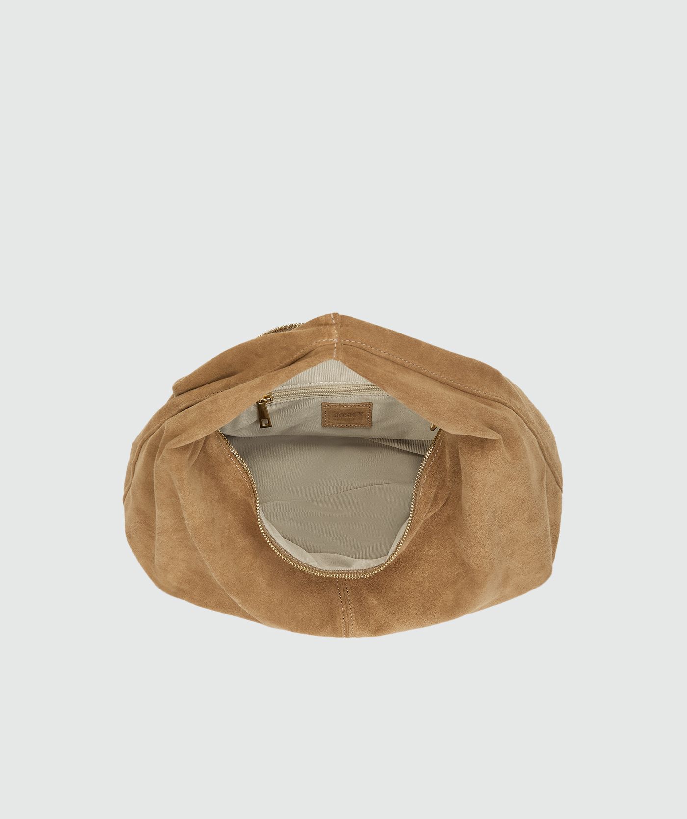 Binnenkant van bruine suede tas zonder model, weergegeven op een lichtgrijze achtergrond