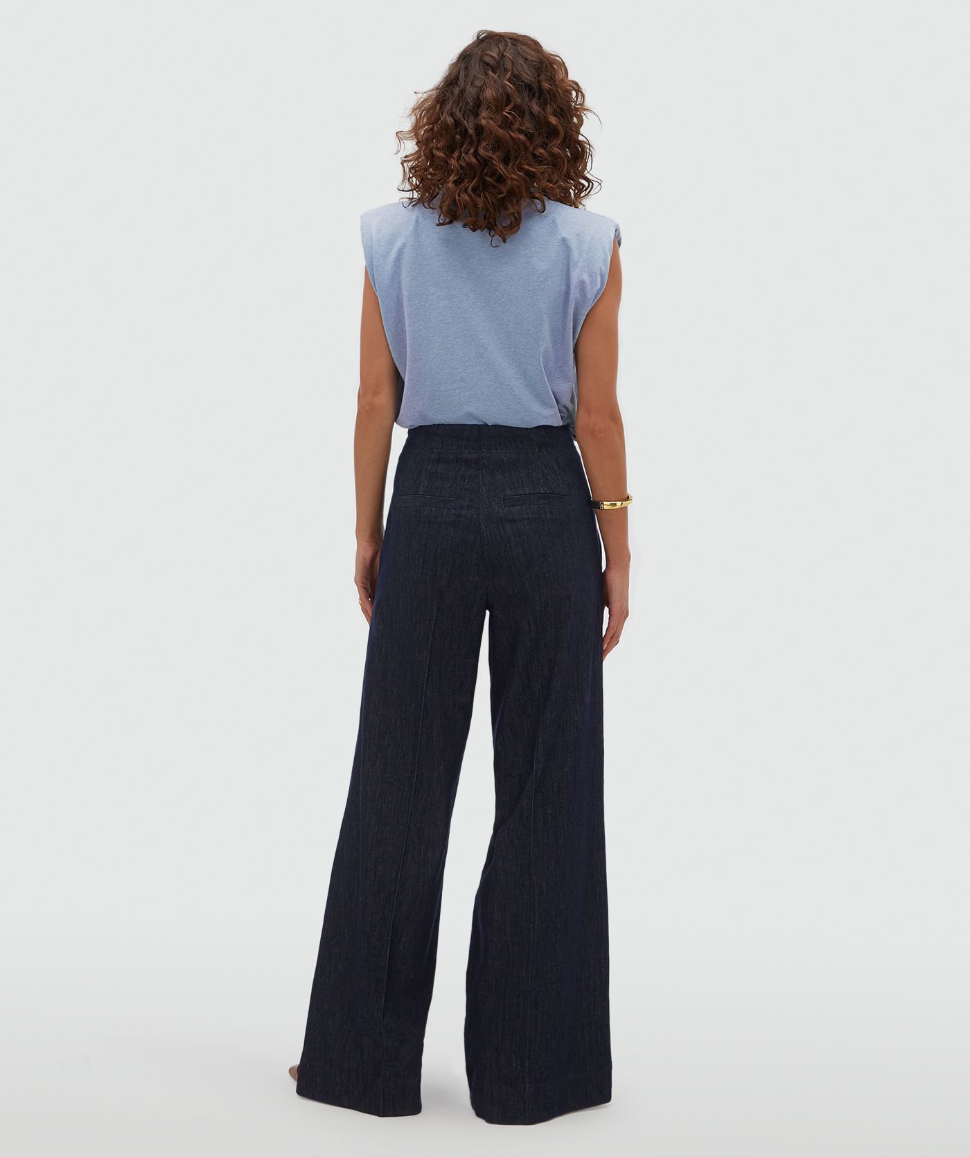 Achteraanzicht van een model in een donkerblauwe pantalon.
