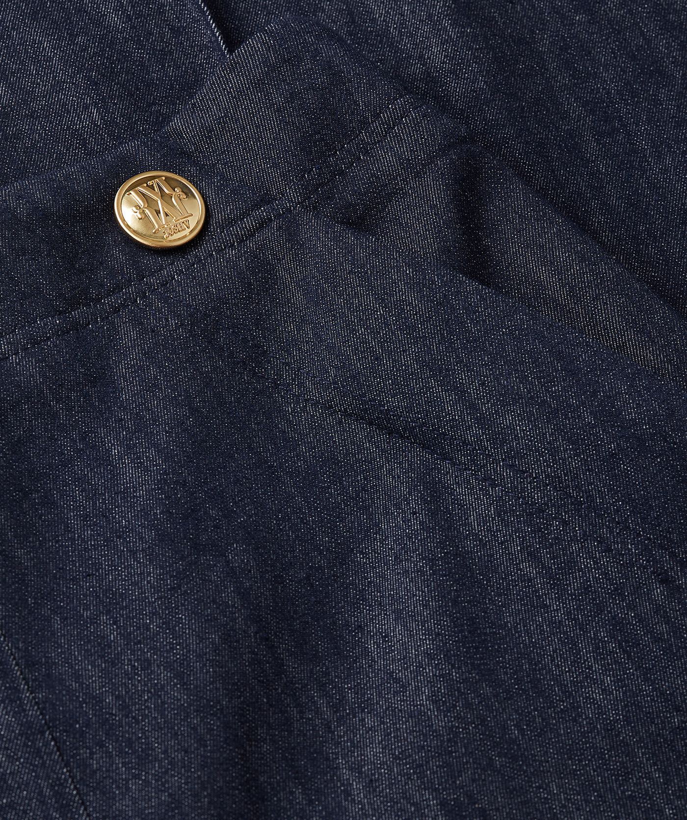 Close-up van de gouden knopen boven aan de donkerblauwe pantalon.