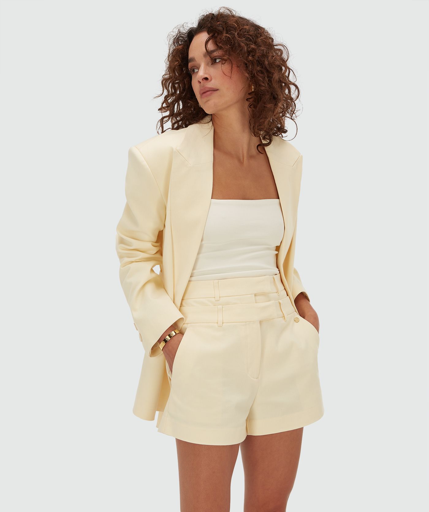 Model draagt een high waisted short in de kleur Butter Yellow 