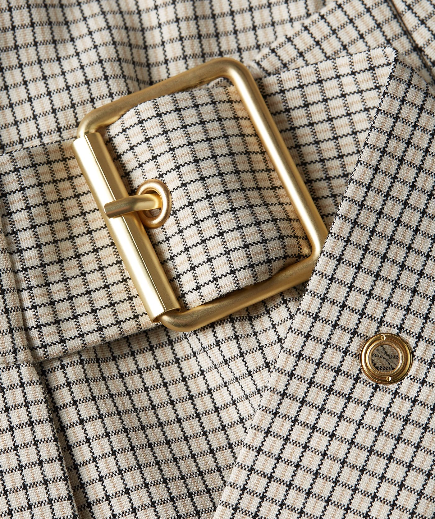 Close-up gespdetail van een mid rise skort in het Stone Check-patroon