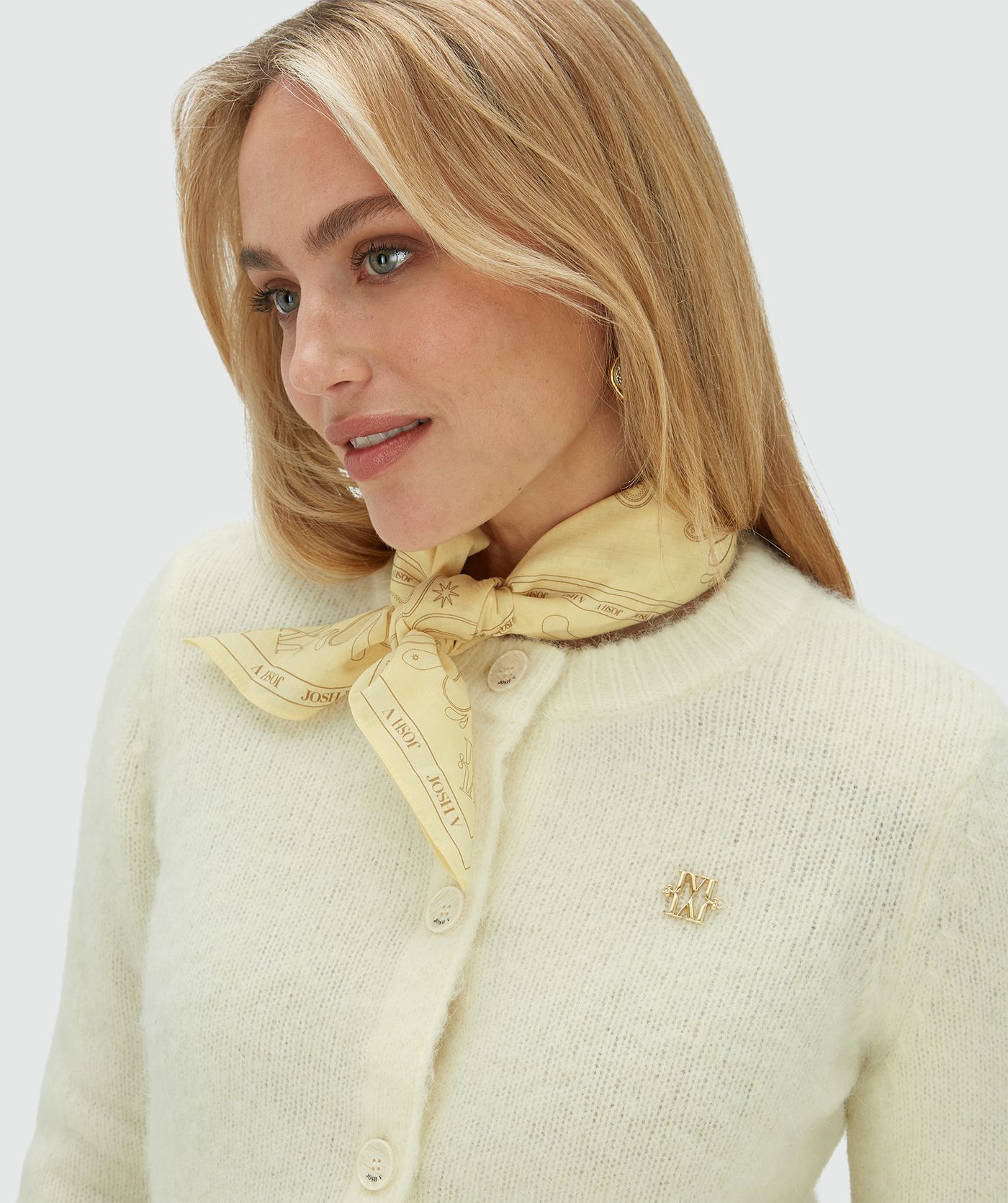 Model draagt een sjaal geknoopt om haar nek in de kleur Butter Yellow