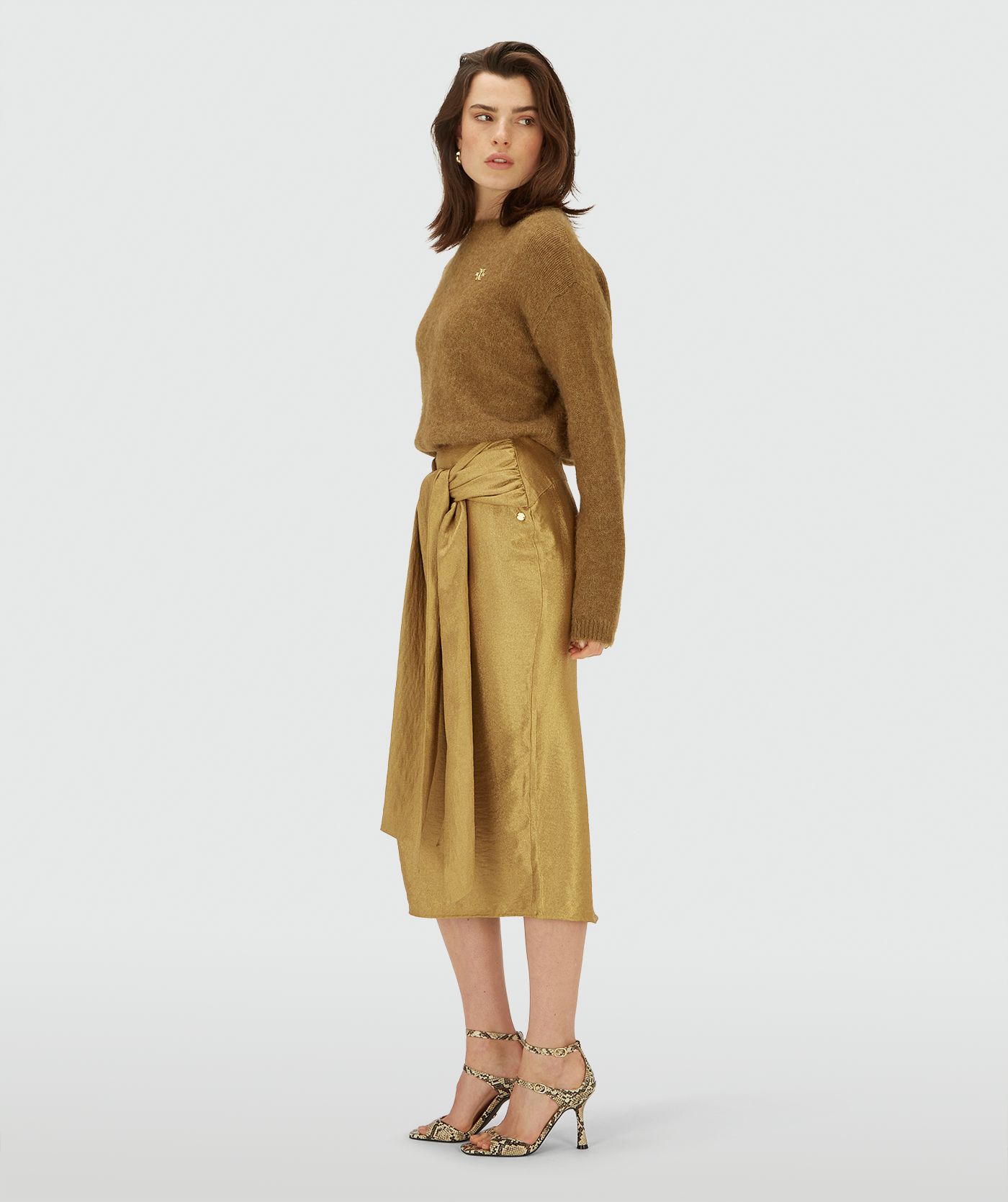 Zijaanzicht van een model in een Dark Gold midi kort met een overslagdetail en een strikceintuur in de taille
