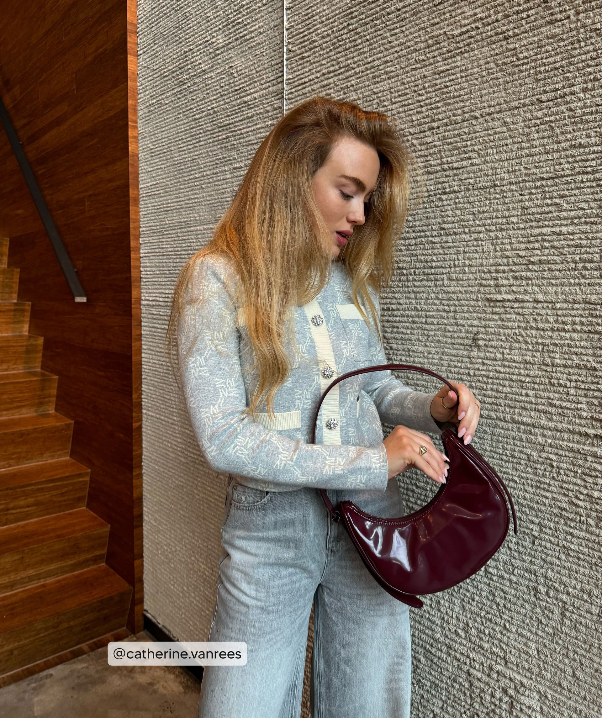 Influencer probeert de donkerrode tas open te maken doormiddel van de rist - Josh V.