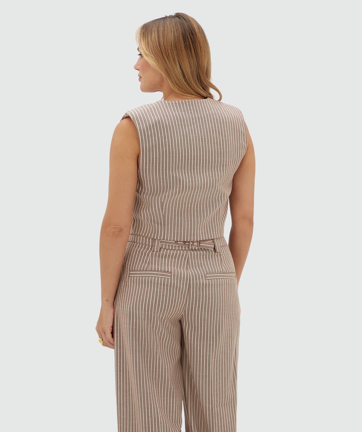 Achteraanzicht van een model in een donkerrood wit gestreept gilet.