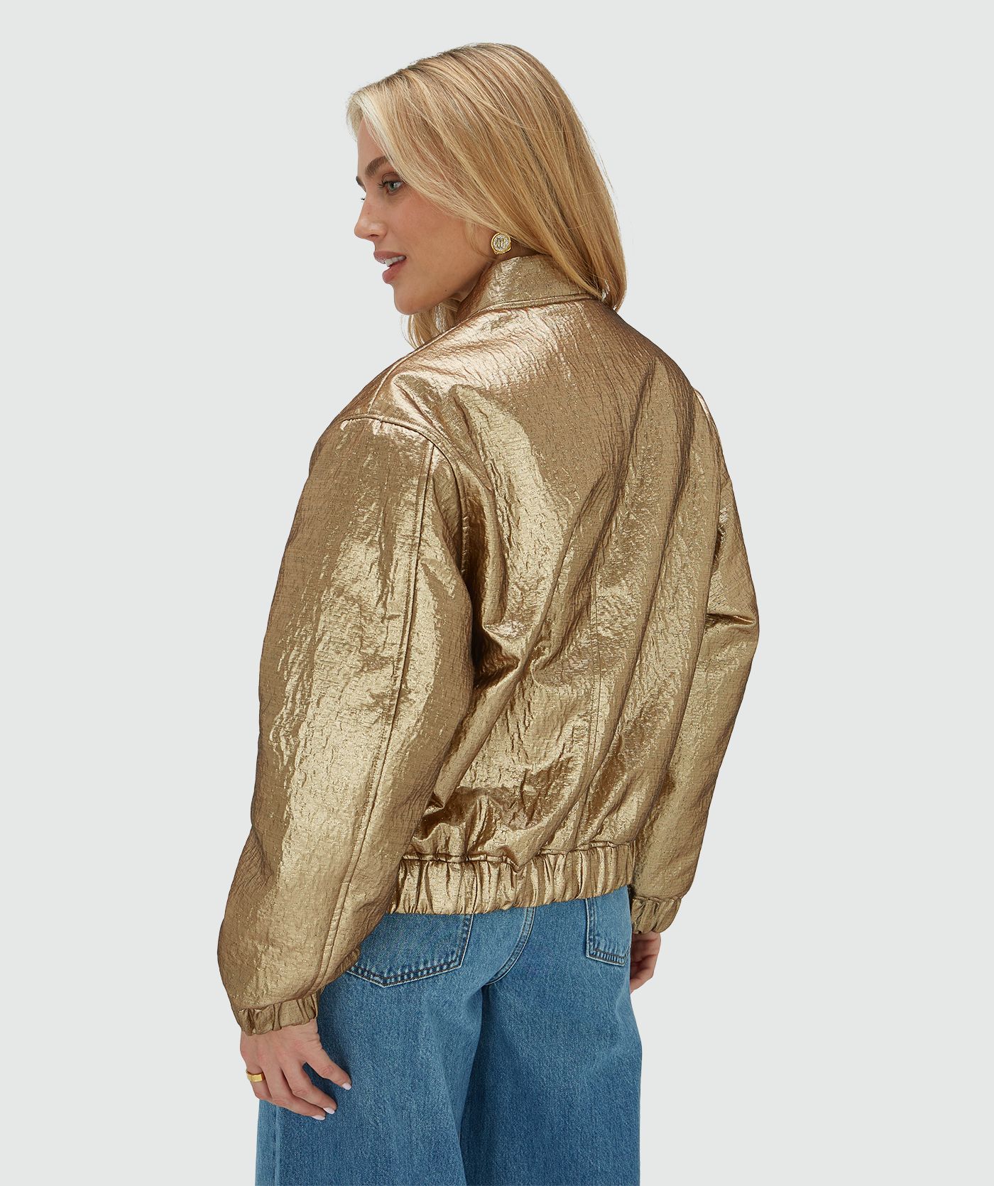 Achteraanzicht van een model in een oversized bomber jacket in metallic in de kleur Bronze Gold