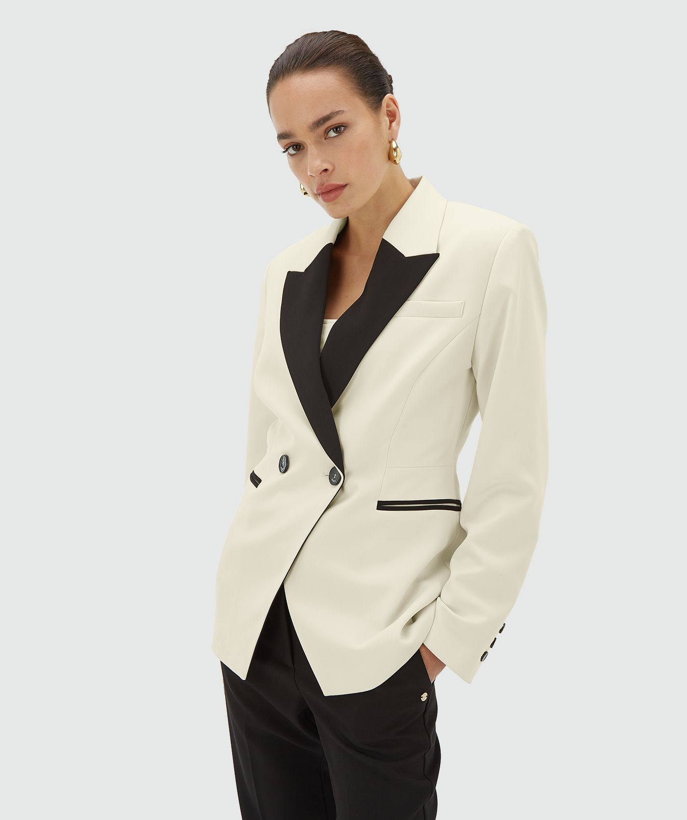 Model draagt een creme blazer met zwarte revers en dubbele knoopsluiting - JOSH V