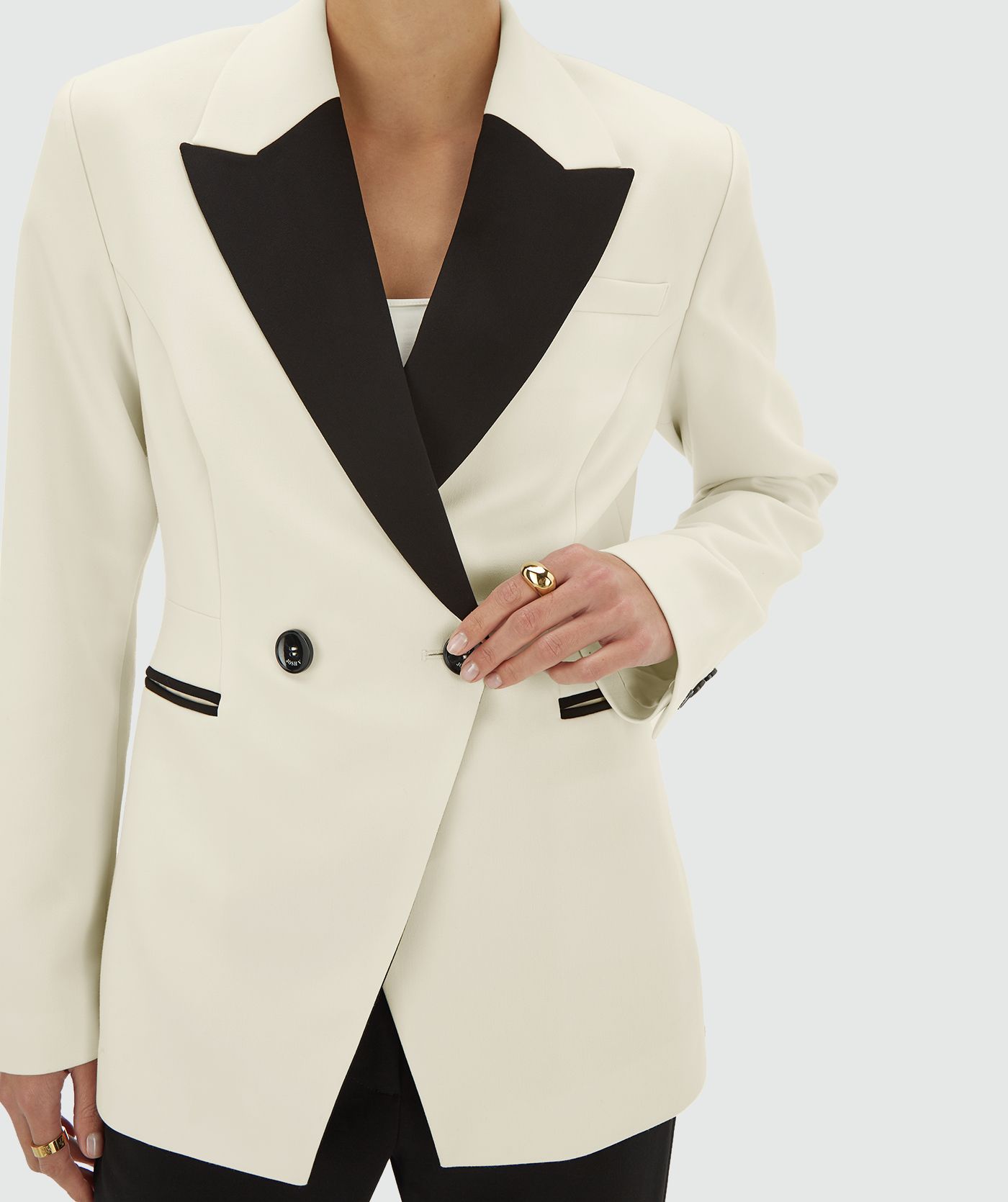 Model draagt een creme blazer met zwarte revers en dubbele knoopsluiting - JOSH V