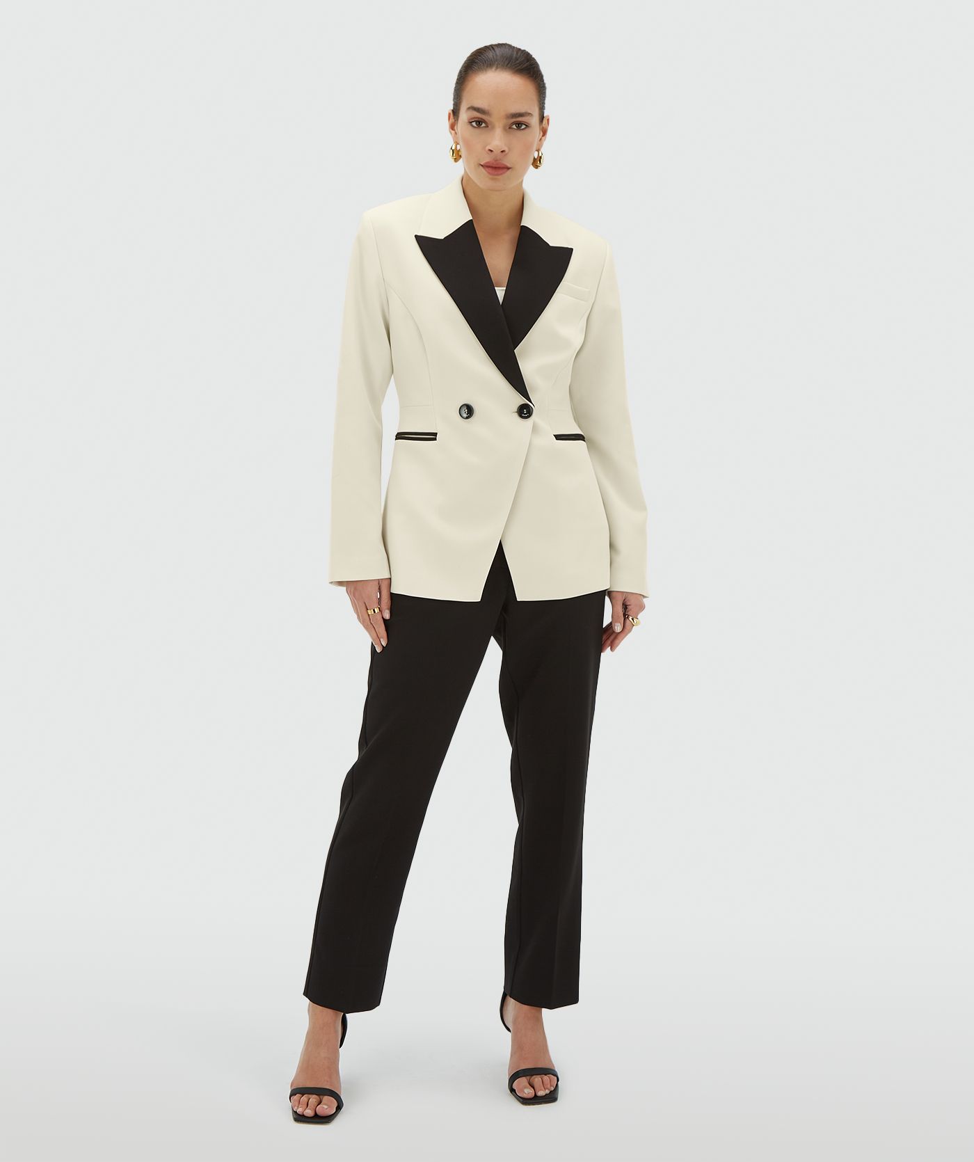 Model draagt een creme blazer met zwarte revers en dubbele knoopsluiting - JOSH V