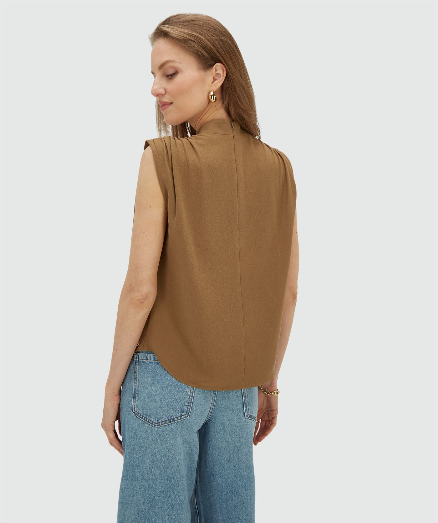 Achteraanzicht van een model in een losvallende top in de kleur Khaki