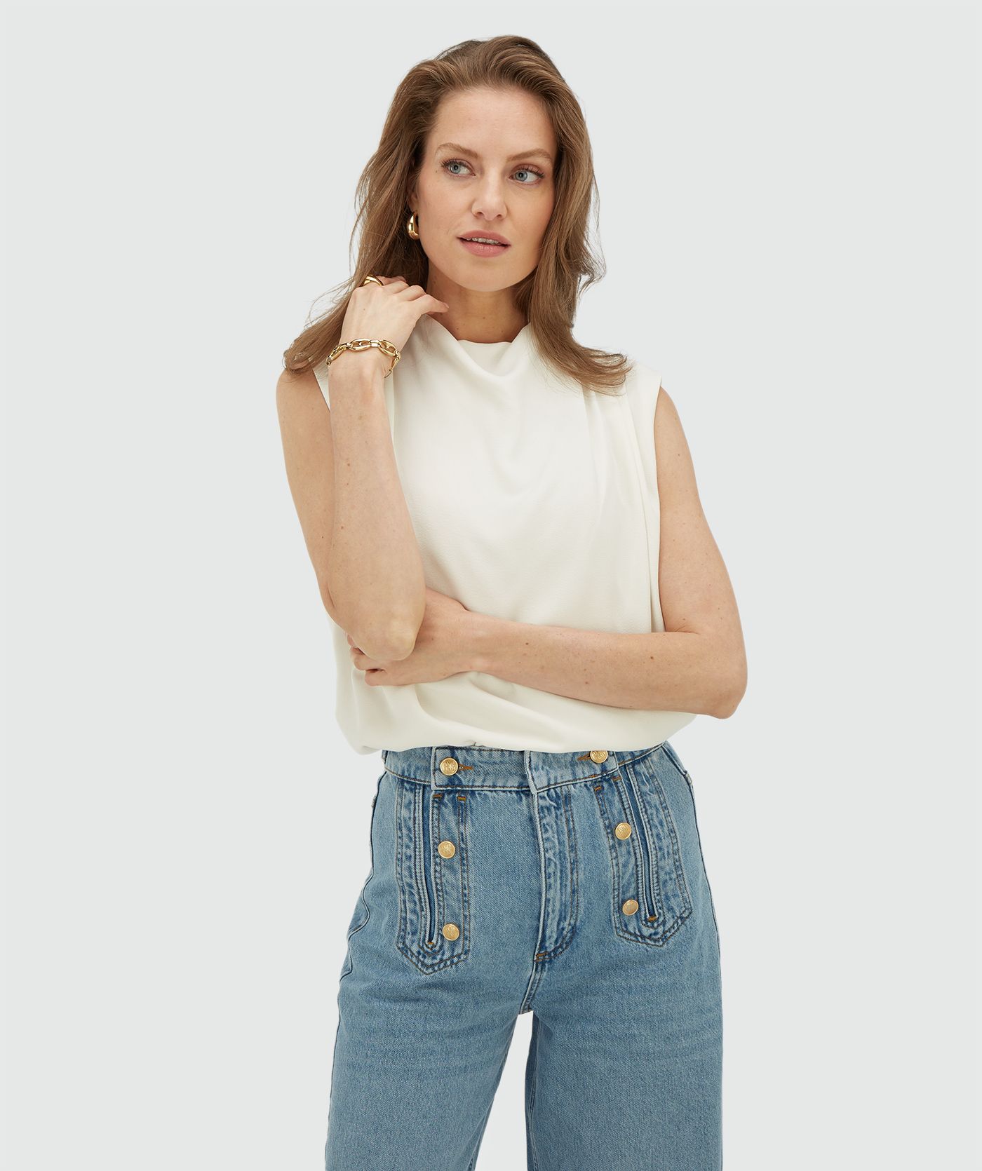 Model draagt een losvallende top in de kleur Off White