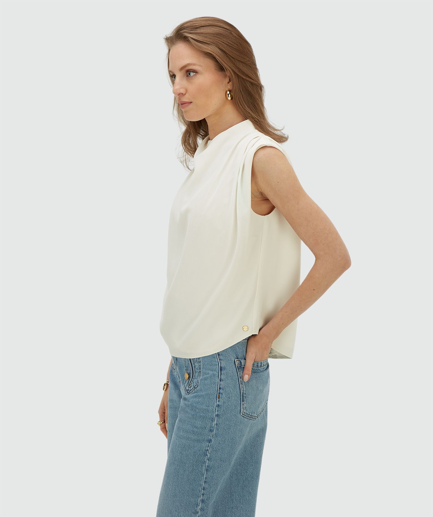 Model draagt een losvallende top in de kleur Off White