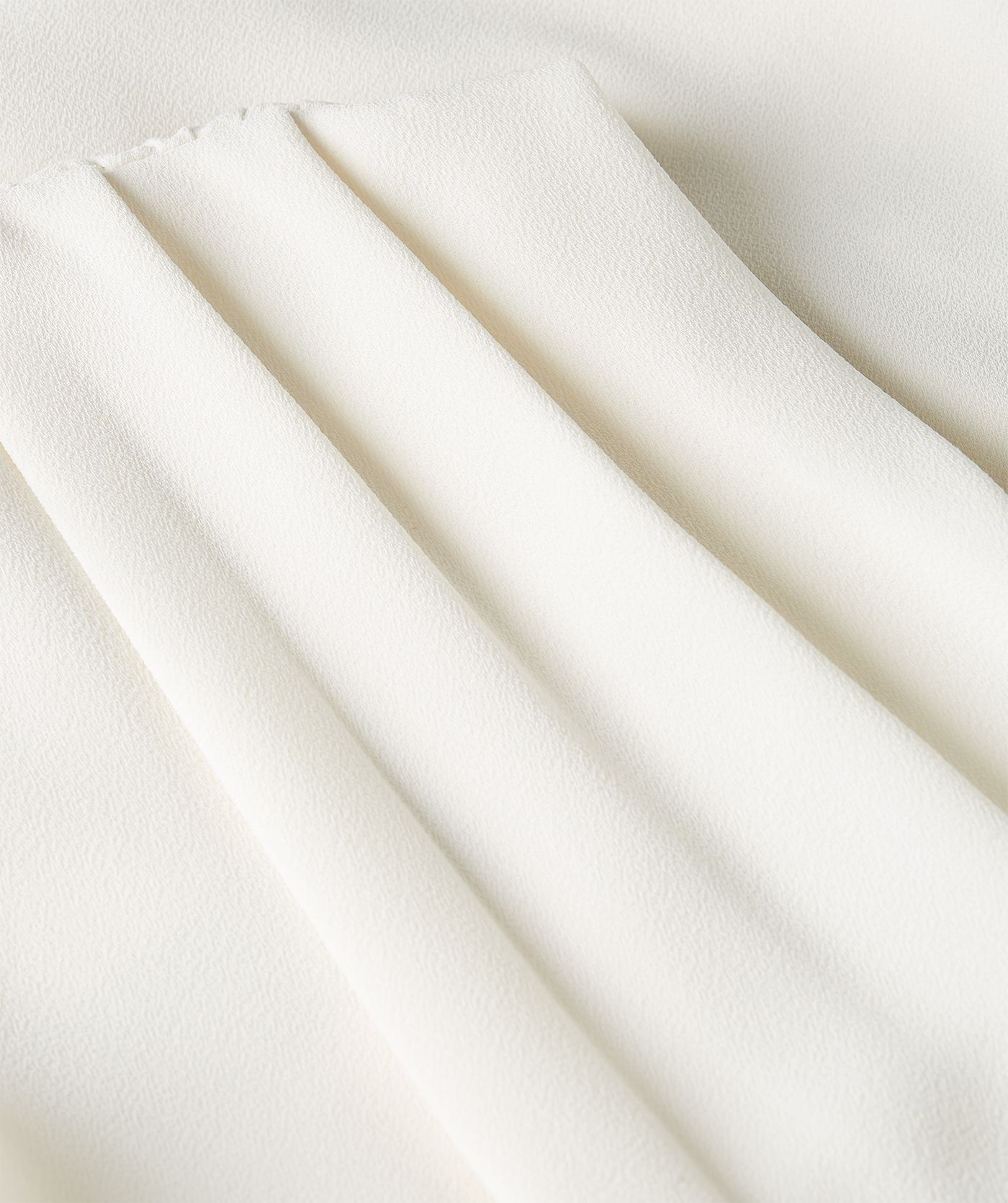 Close-up van een losvallende top in de kleur Off White