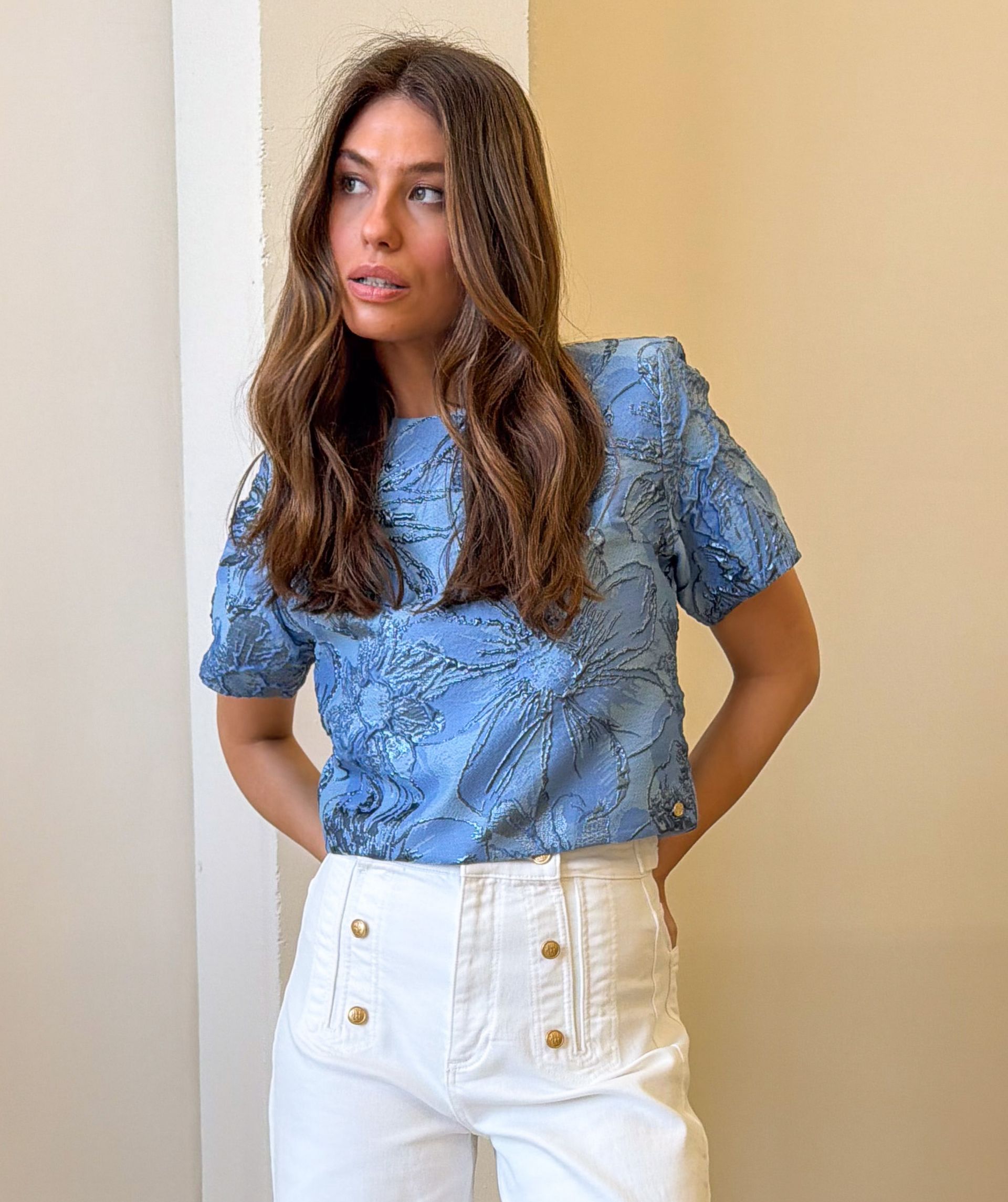 Model draagt een cropped top met metallic details in de kleur Fresh Blue
