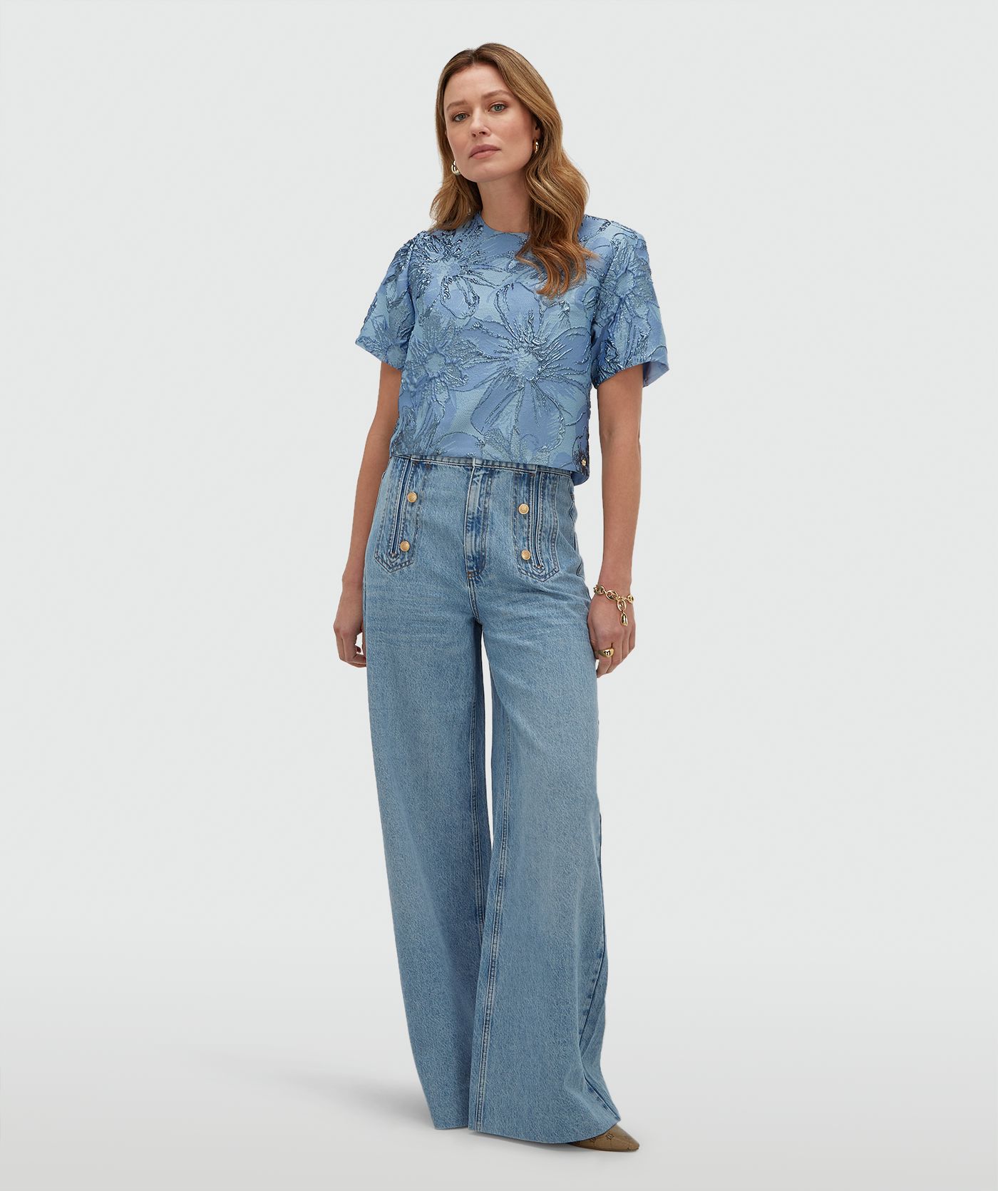Model draagt een cropped top met metallic details in de kleur Fresh Blue