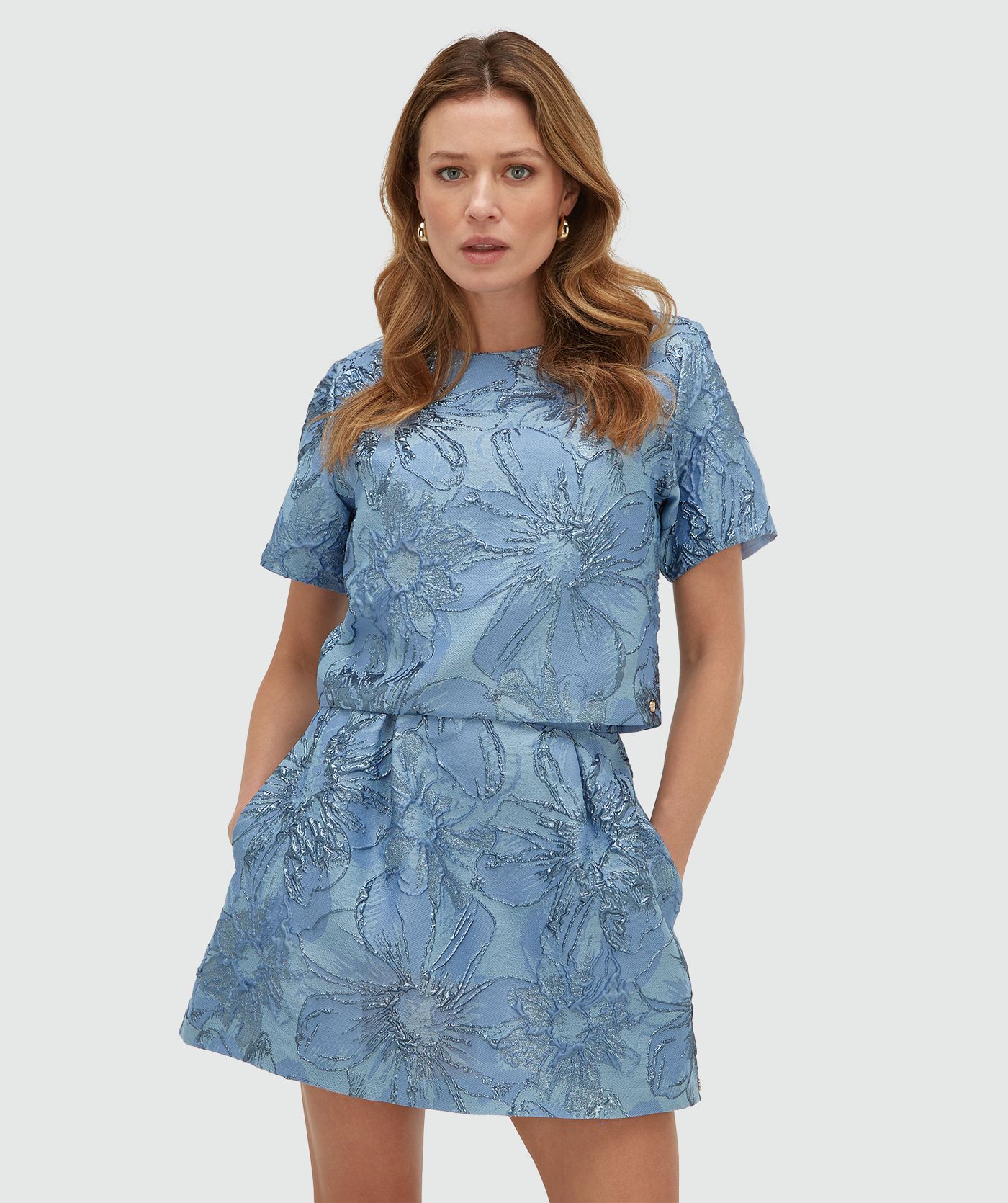 Model draagt een cropped top met metallic details in de kleur Fresh Blue