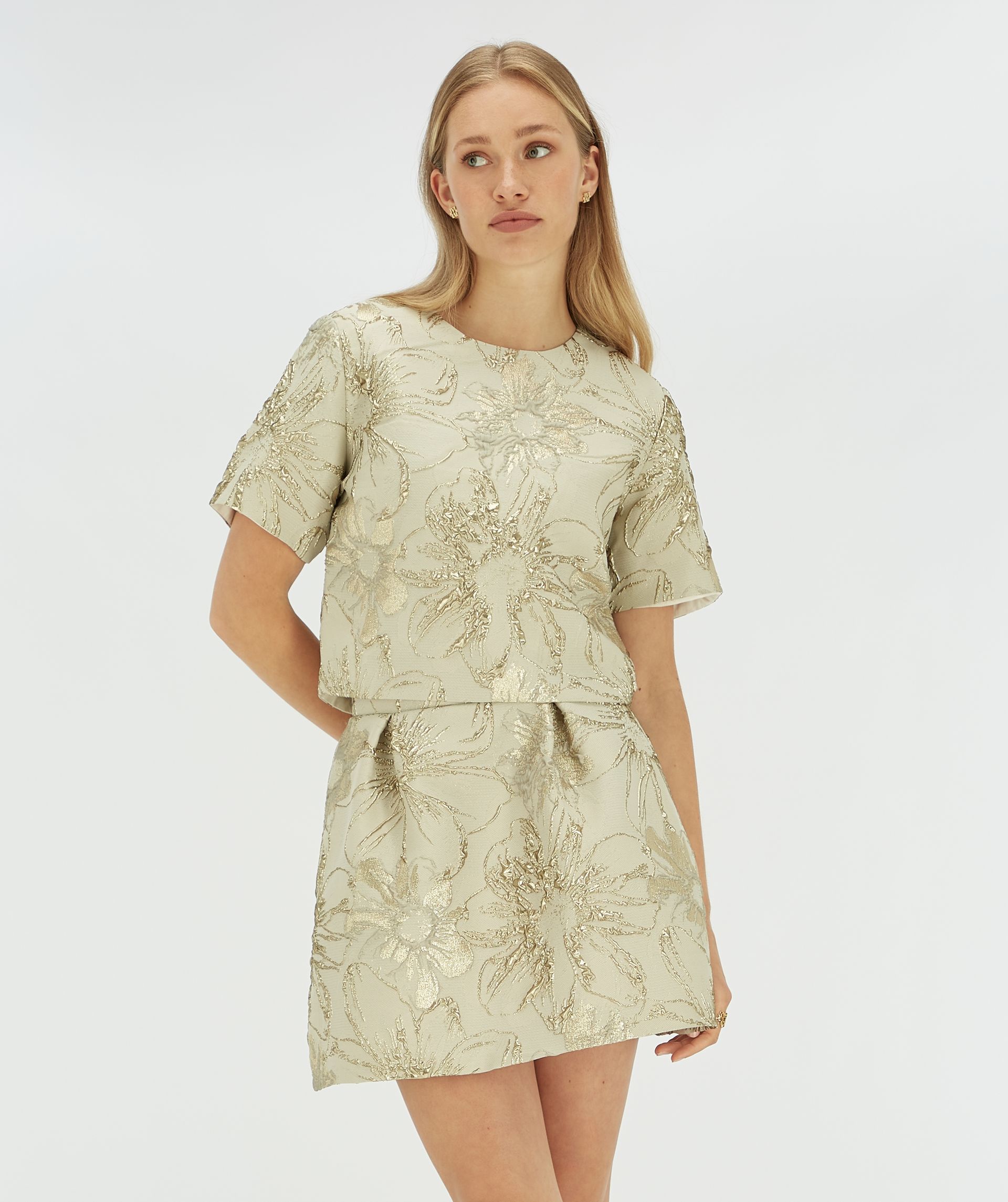 Model draagt een cropped top met bloemen print.