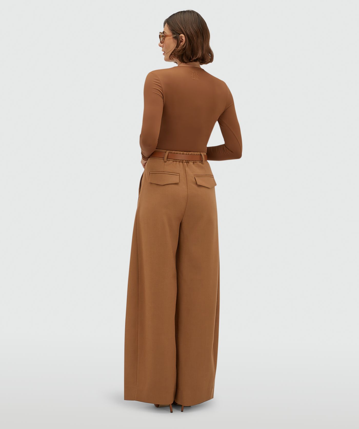 Achteraanzicht van een model in een high waisted balloon fit pantalon in Cognac