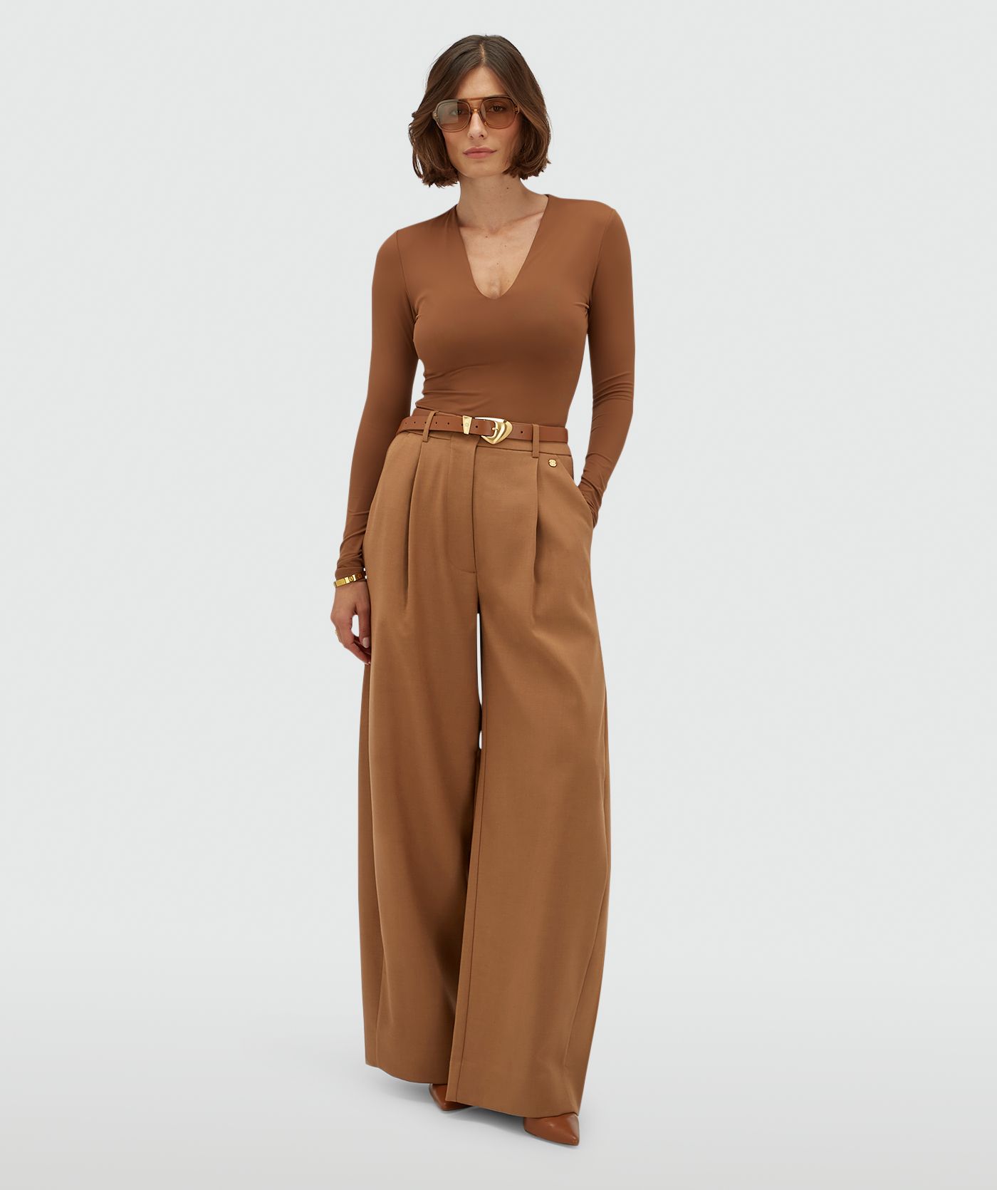 Model draagt een high waisted balloon fit pantalon in de kleur Cognac