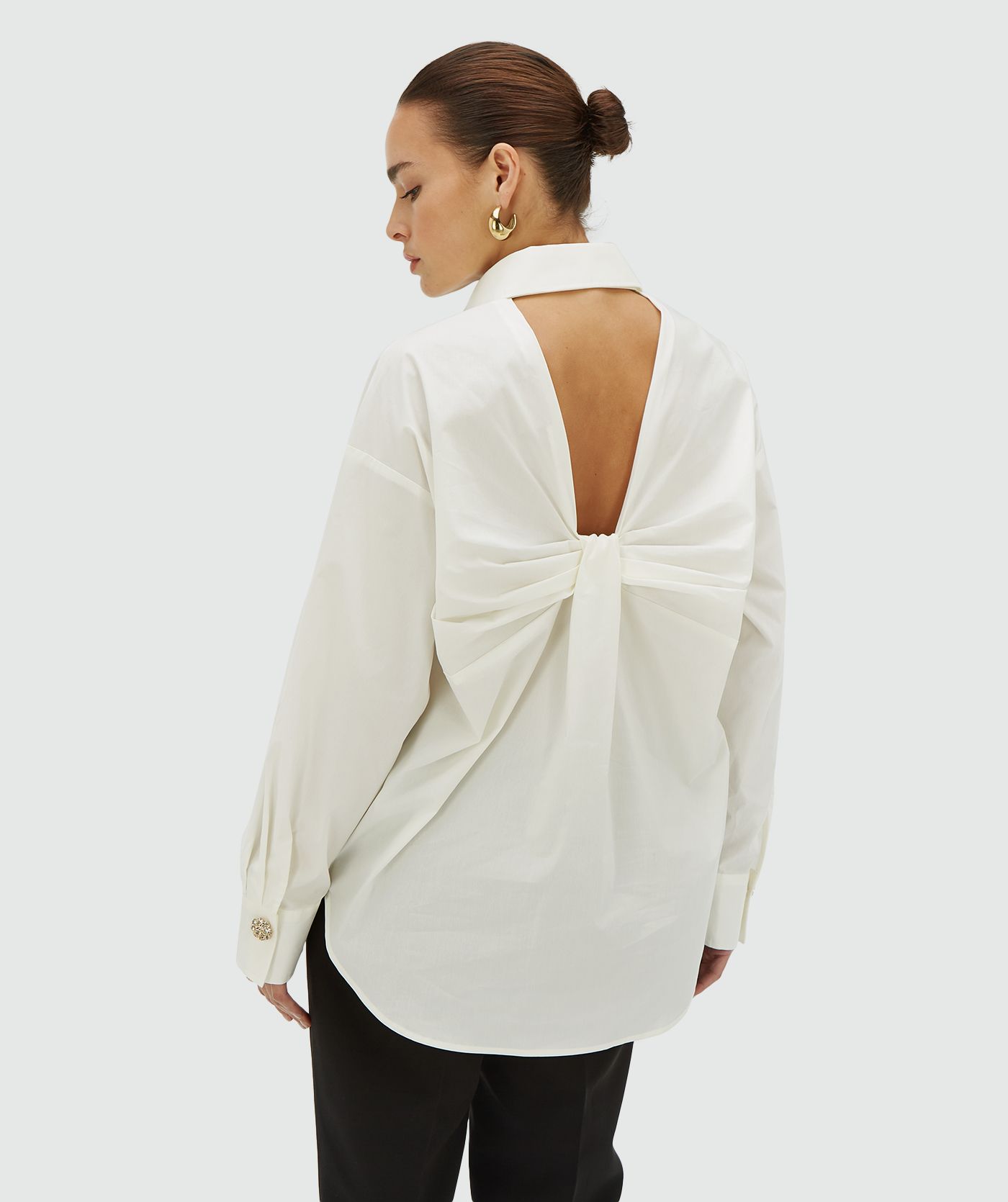 Achteraanzicht van een model met een off white blouse met een open rug met strikdetail - JOSH V