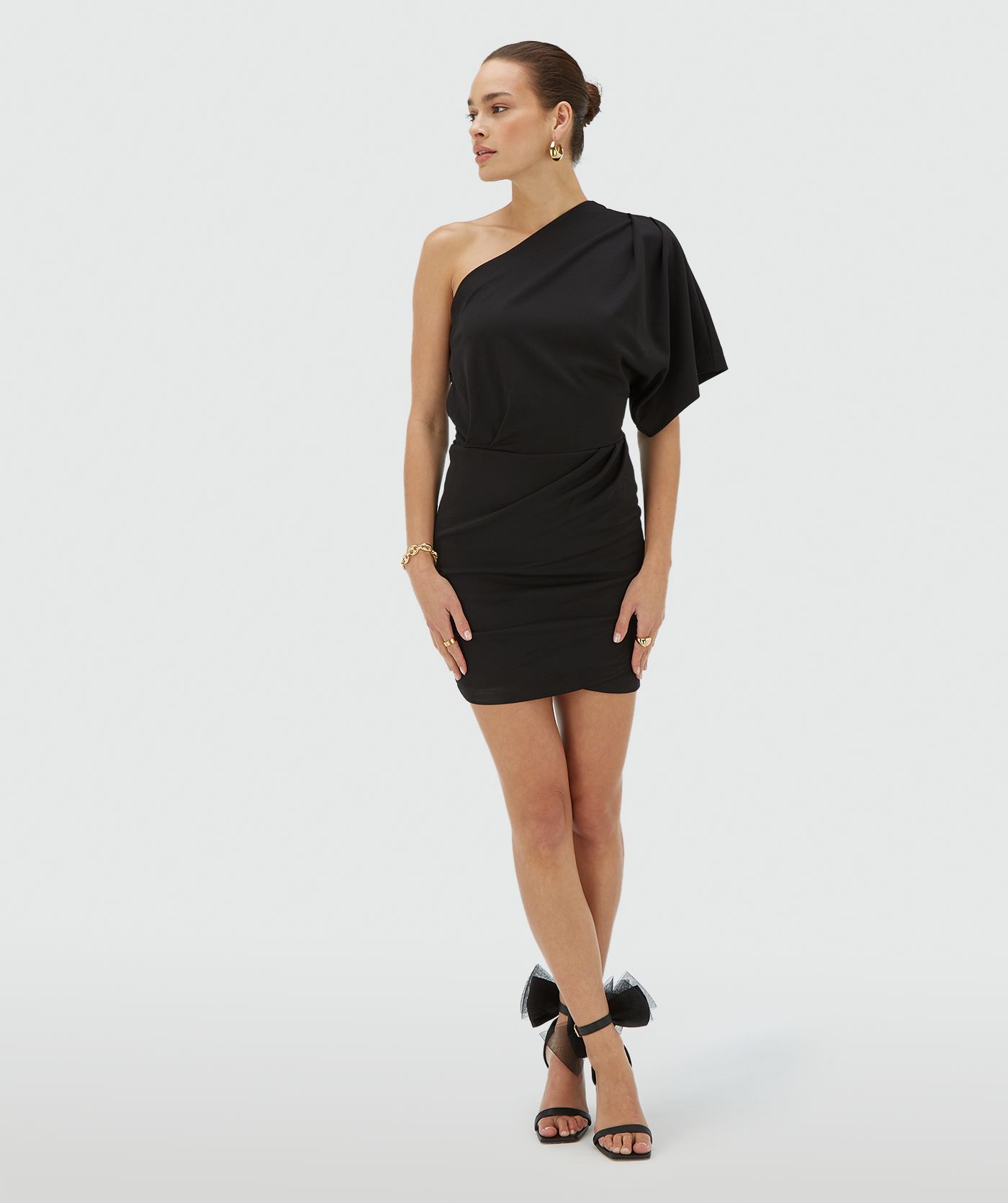 Model draagt een aangesloten zwarte one shoulder jurk met asymmetrische halslijn - JOSH V