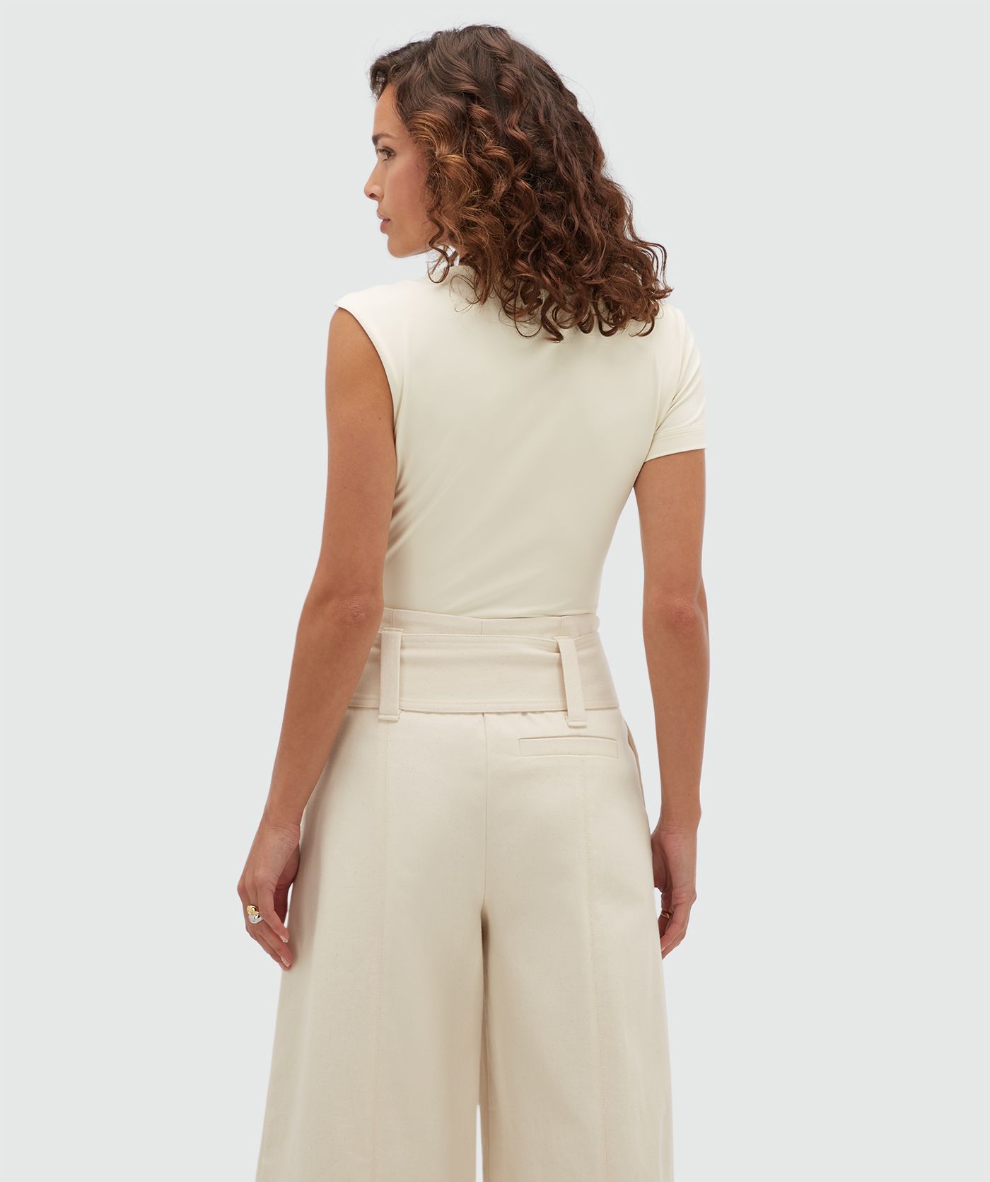 Achteraanzicht van een model in een gebroken witte body.
