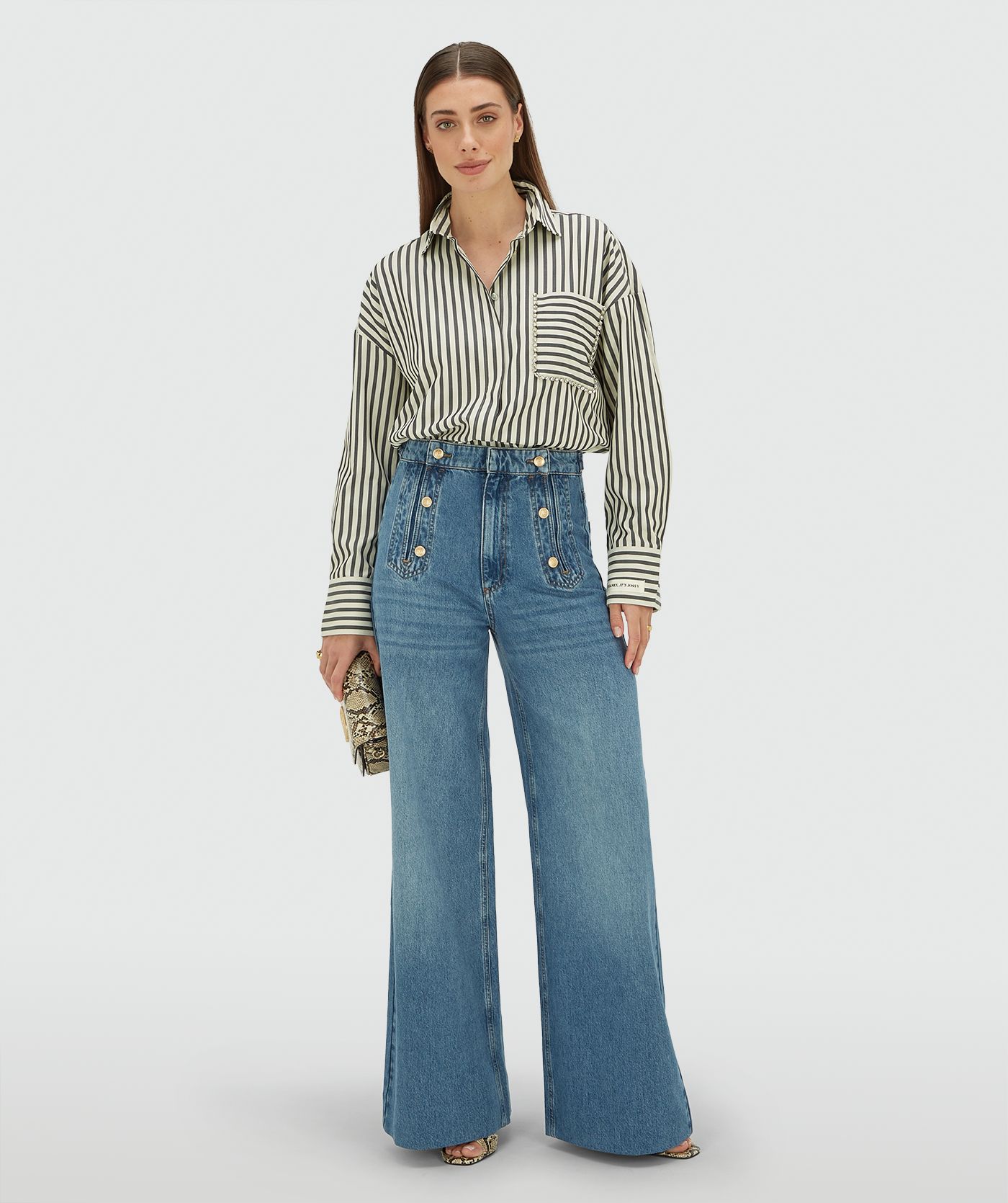 Model draagt een oversized blouse met strepen in de kleur Blue Stripe met strass steentjes rond de borstzak