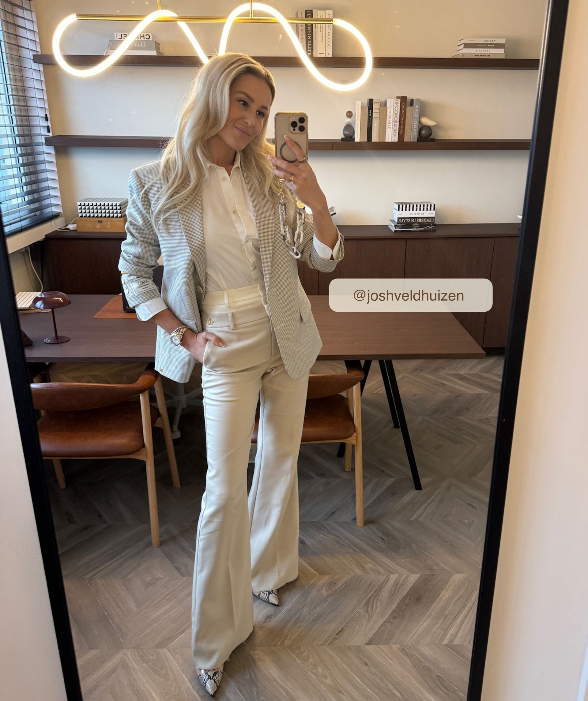 Model draagt een high rise flared pantalon met een dubbele band in de kleur Ecru Melange, hierbij is de bovenste band van de pantalon in Ecru en de rest van de broek in de kleur Melange.