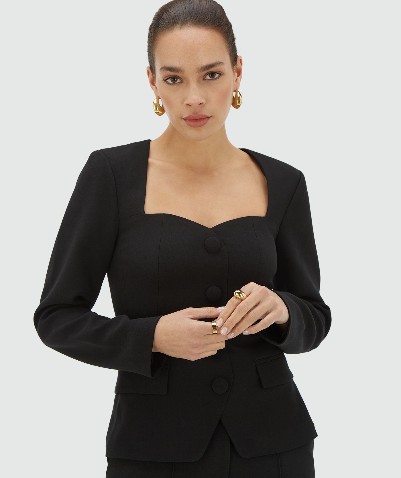 Model draagt een zwarte fitted bustier top met hartvormige halslijn - Josh V