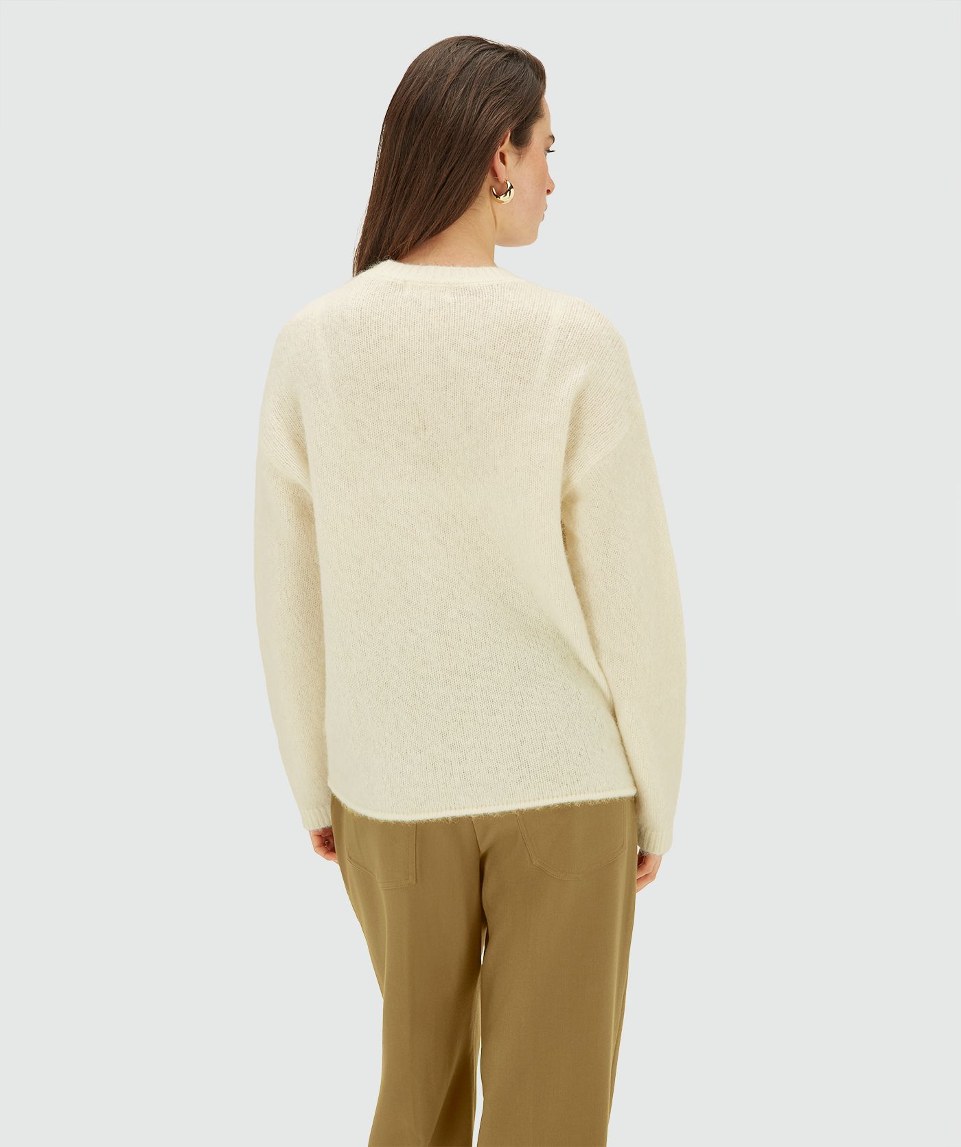 Achteraanzicht van een model in een Light Ecru Melange trui 