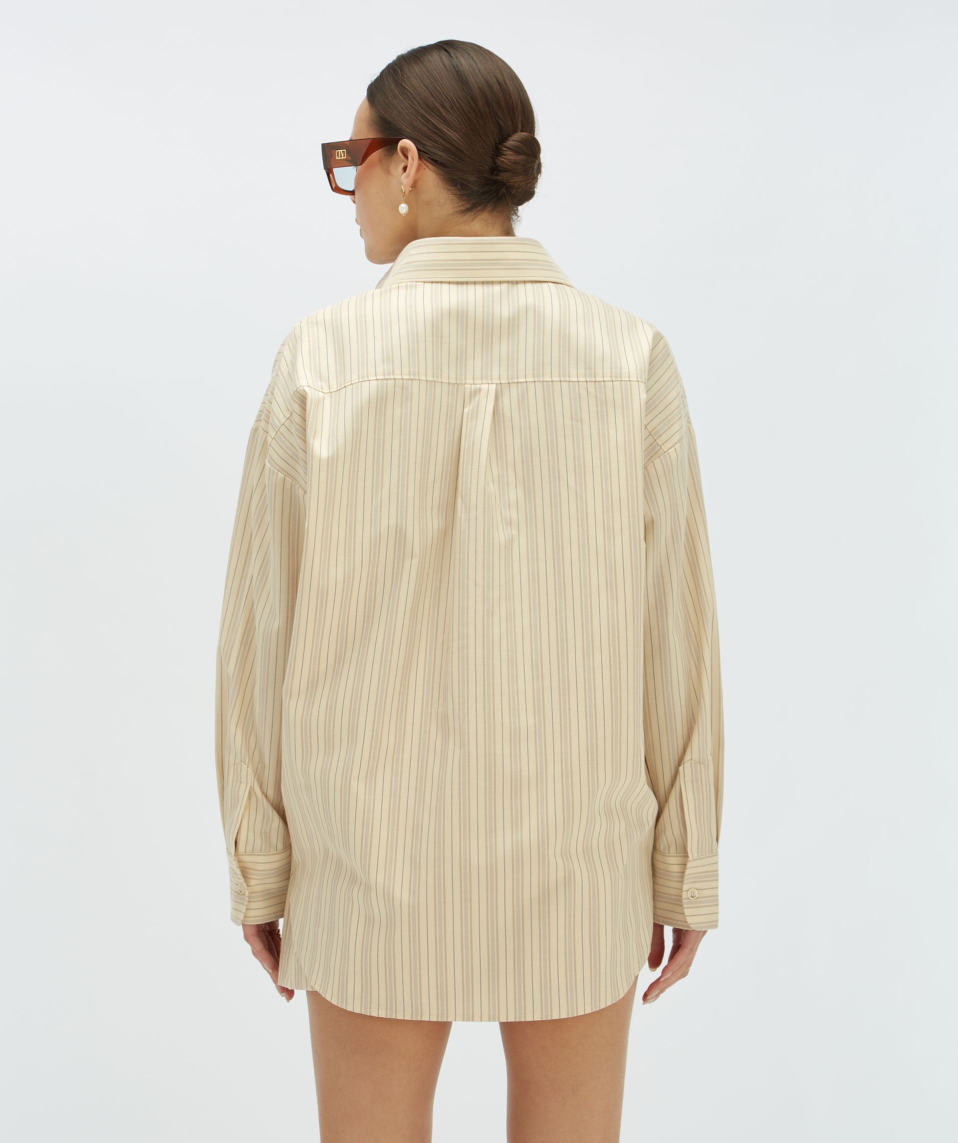 Achteraanzicht van een model in een oversized blouse met beige strepen - Josh V.
