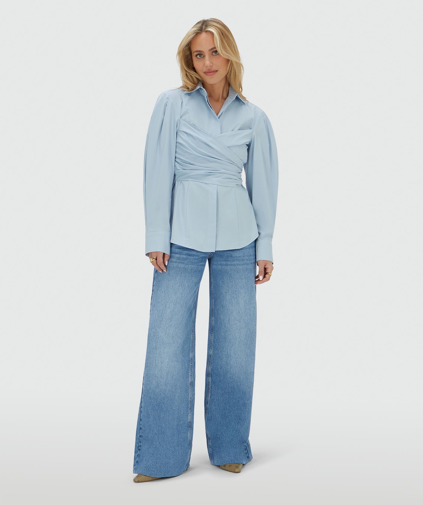 Model draagt een fitted blouse in het blauw