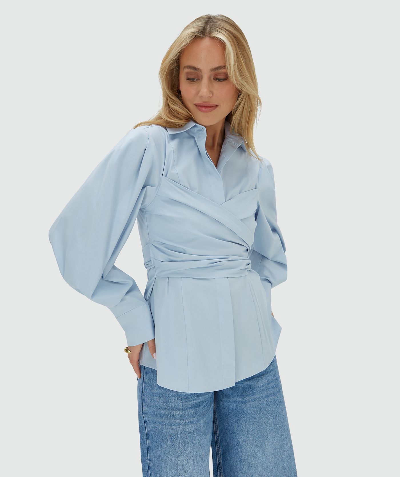 Model draagt een fitted blouse in het blauw