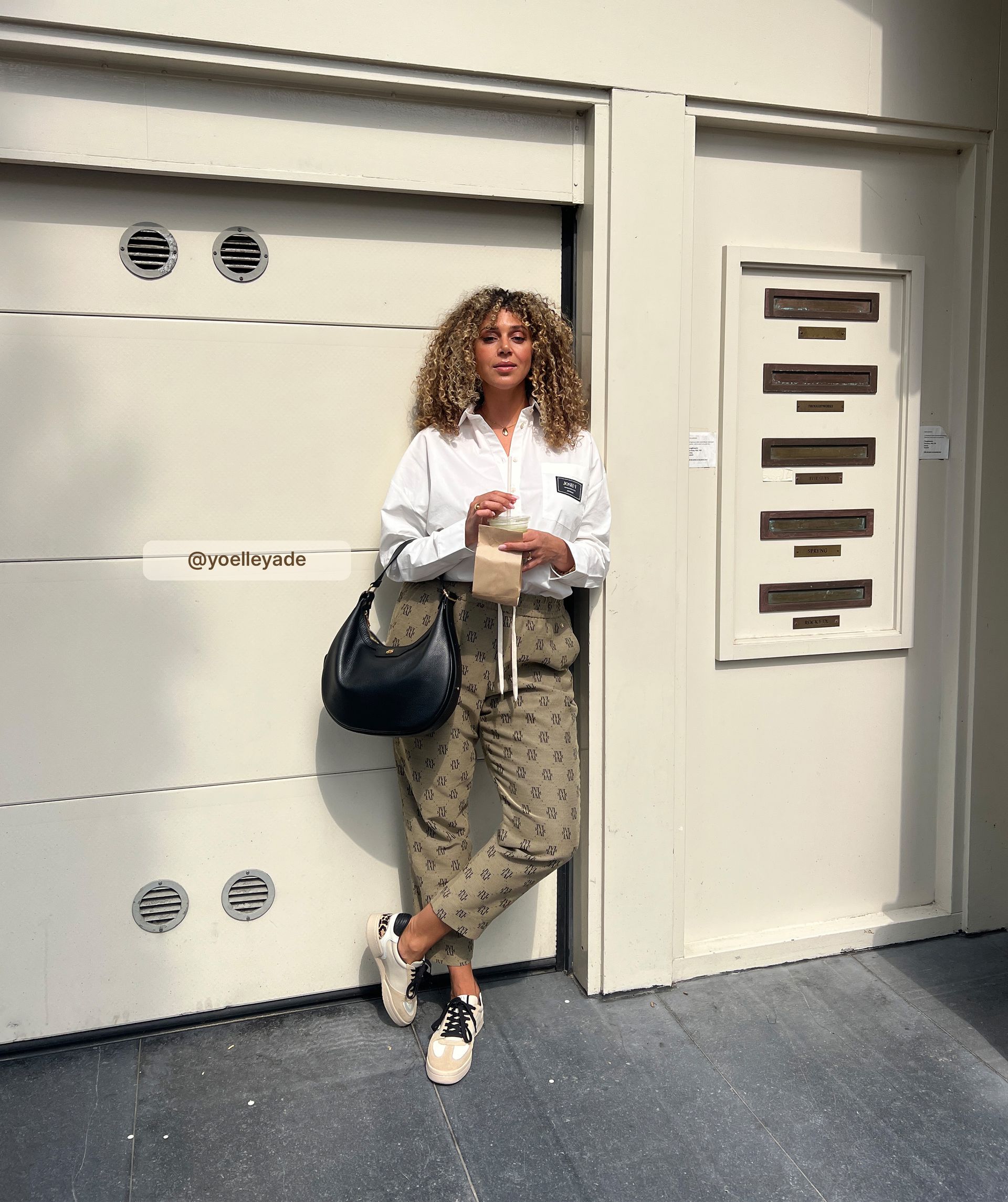 Influencer draagt de sneakers met de zwarte veters gecombineerd met een bruine broek met Josh V logo's.