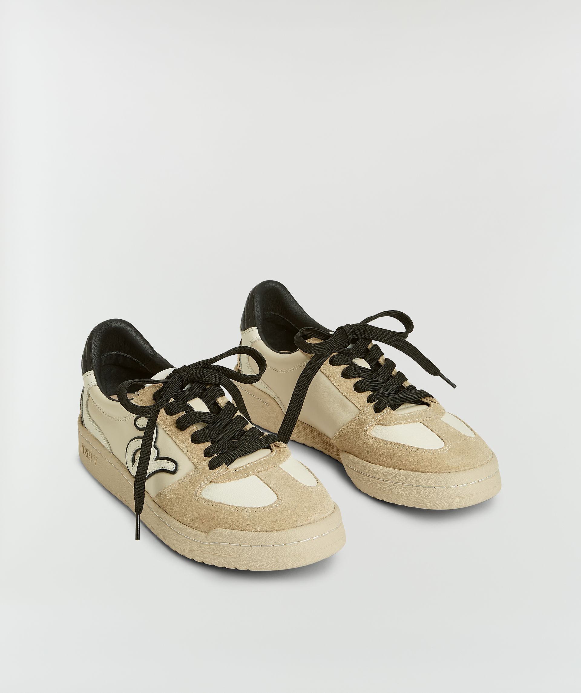 Sneakers met luipaardprint zonder model, weergegeven op een lichtgrijze achtergrond.