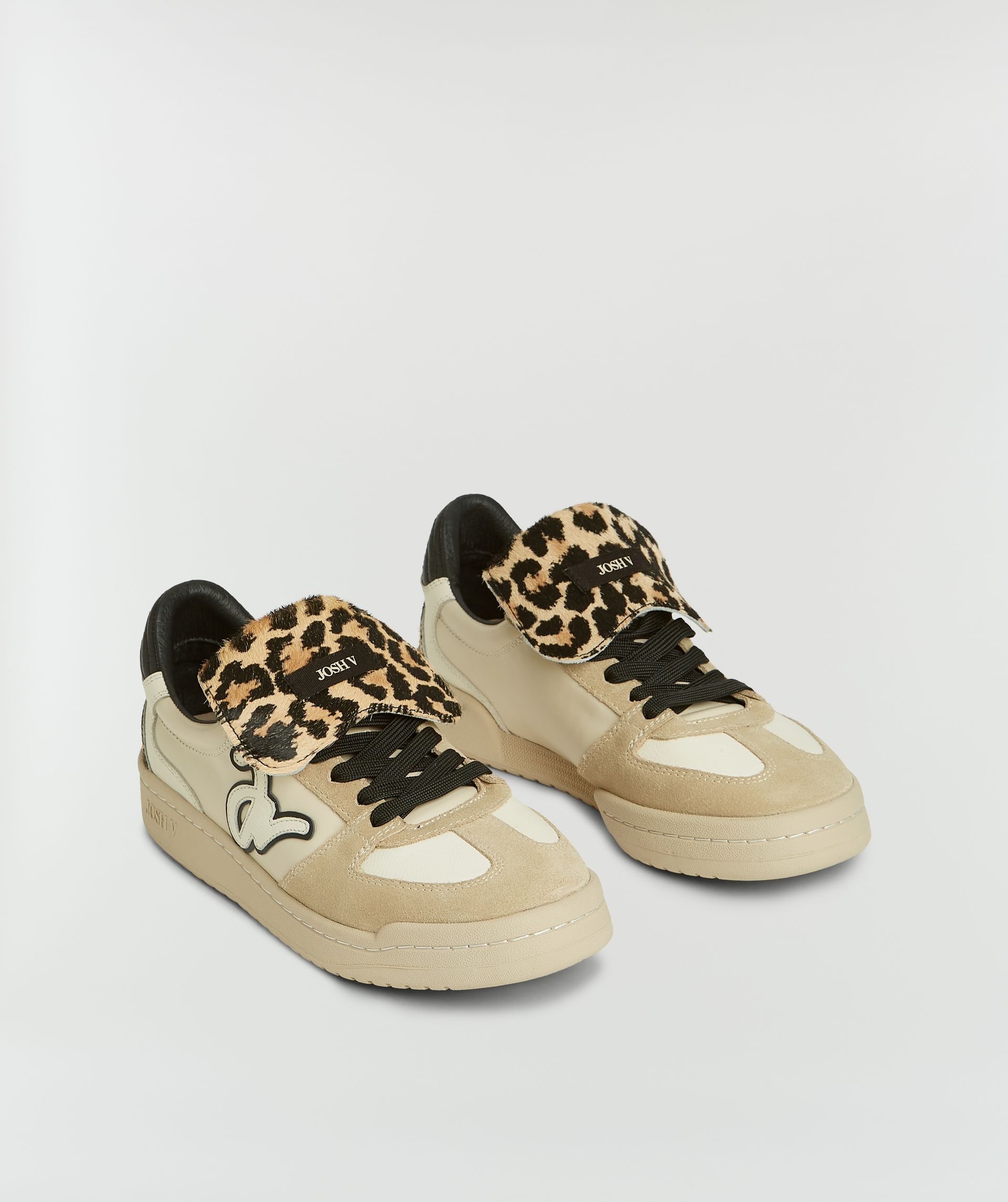 Sneakers met luipaardprint zonder model, weergegeven op een lichtgrijze achtergrond.