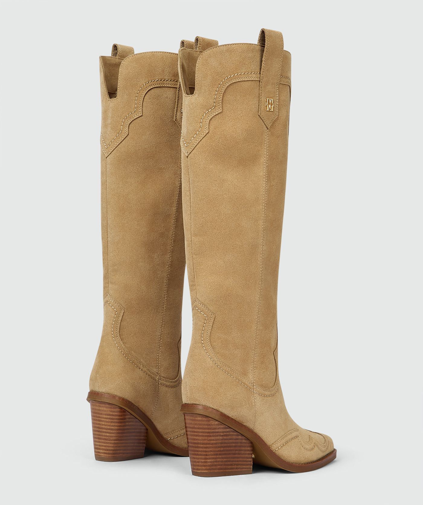 Beige laarzen van suède, weergegeven op een lichtgrijze achtergrond