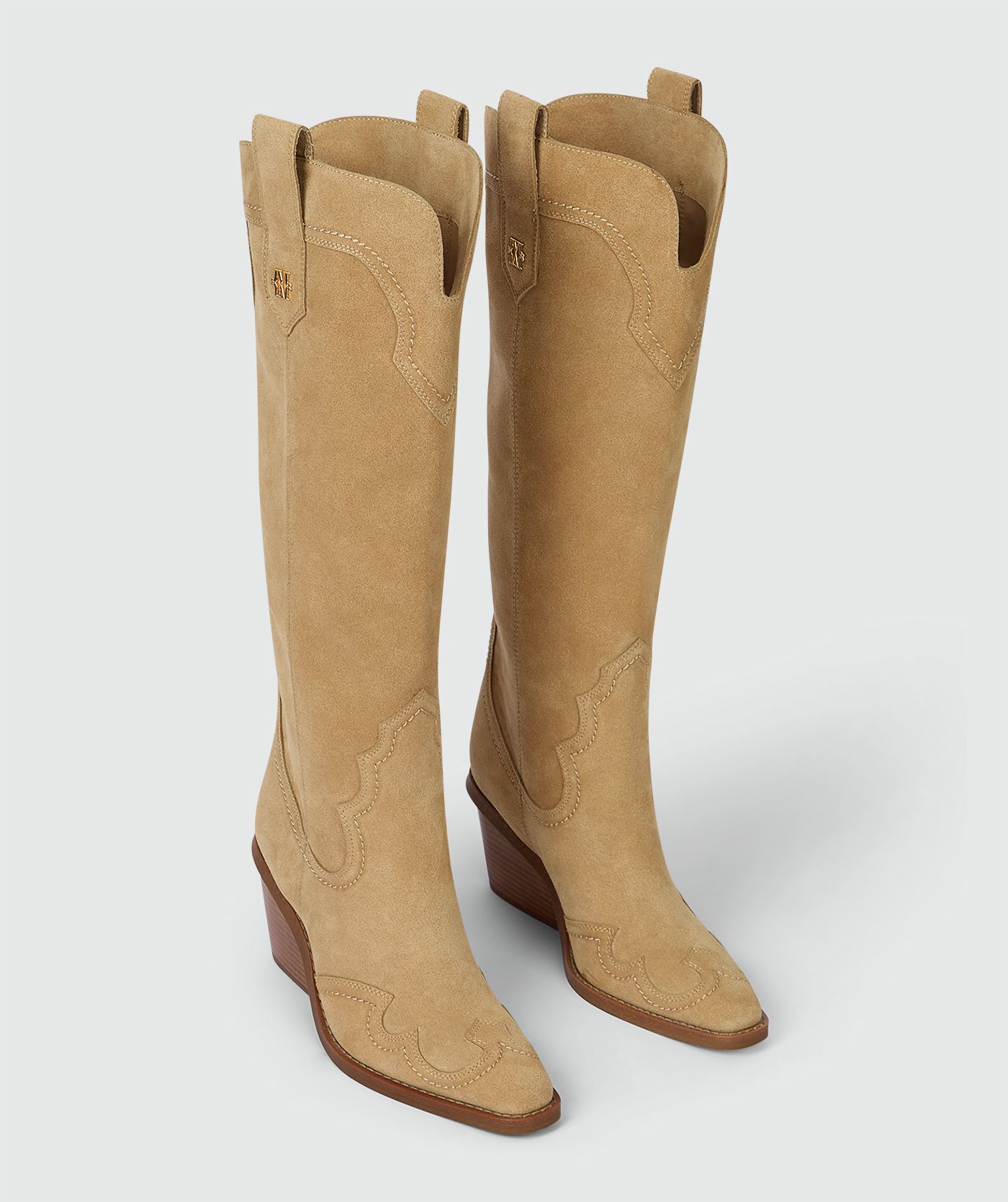 Beige laarzen van suède, weergegeven op een lichtgrijze achtergrond